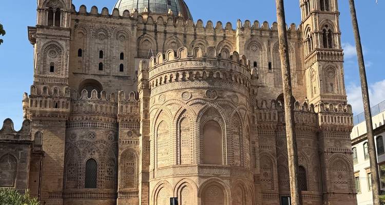 Impressive facade of Palermo Cathedral with intricate Norman-Arab architecture under clear skies.