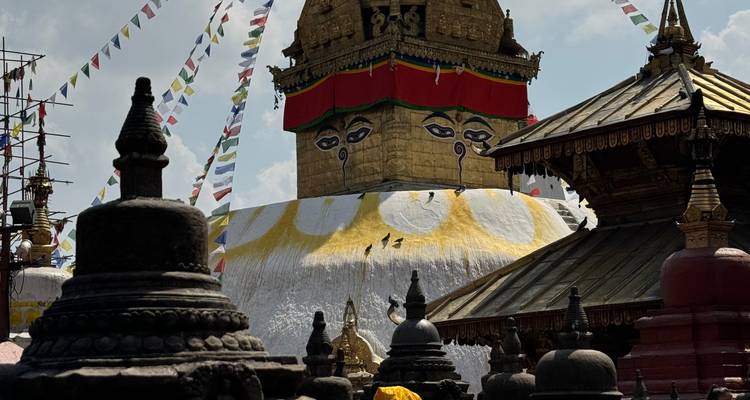 A Buddhist stupa with prayer flags against a blue sky