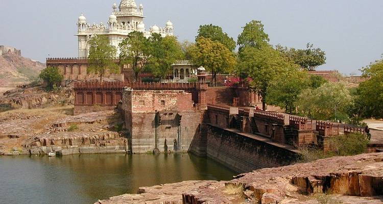 Historical fortification with trees around water.