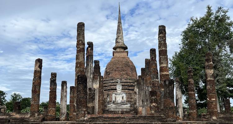 Ancient temple ruins with a spire surrounded by pillars.