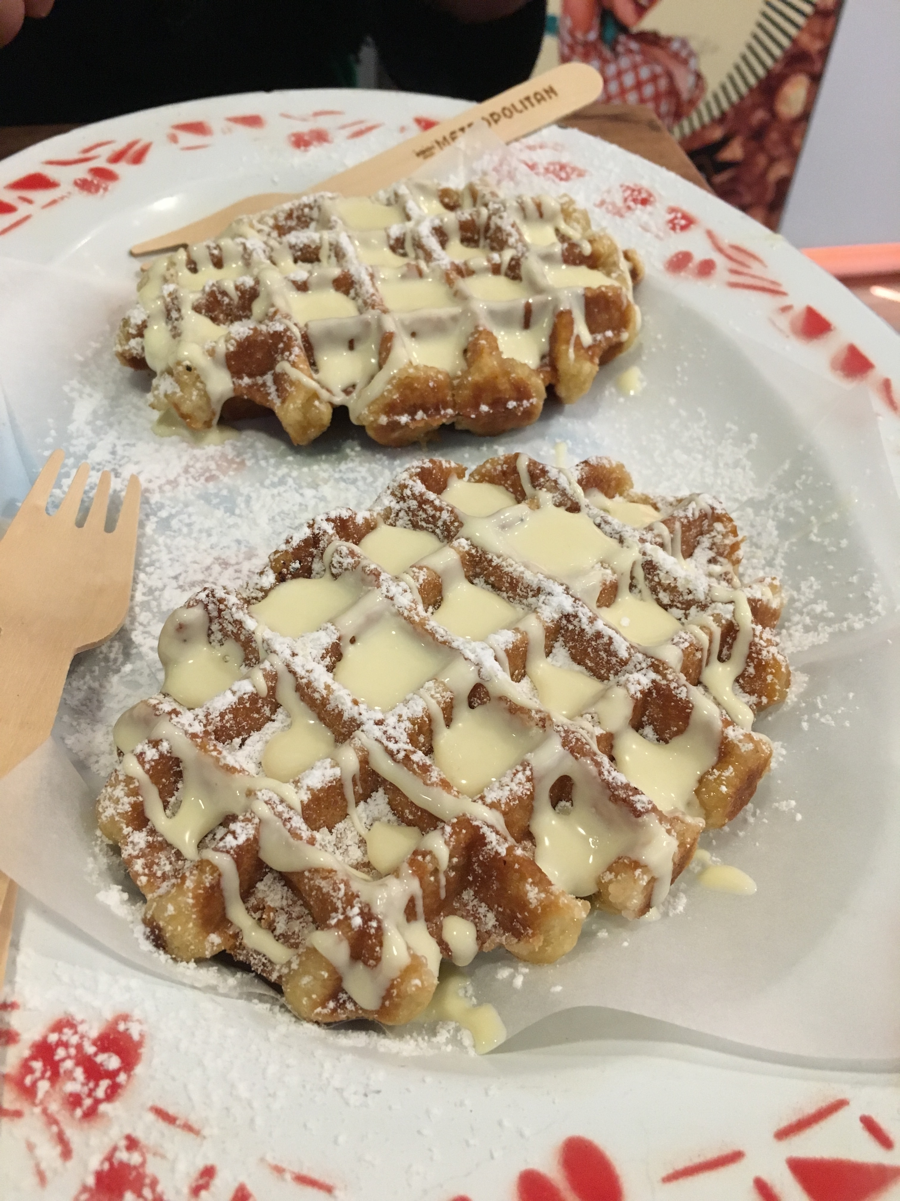 Close-up of waffles with powdered sugar and sauce.