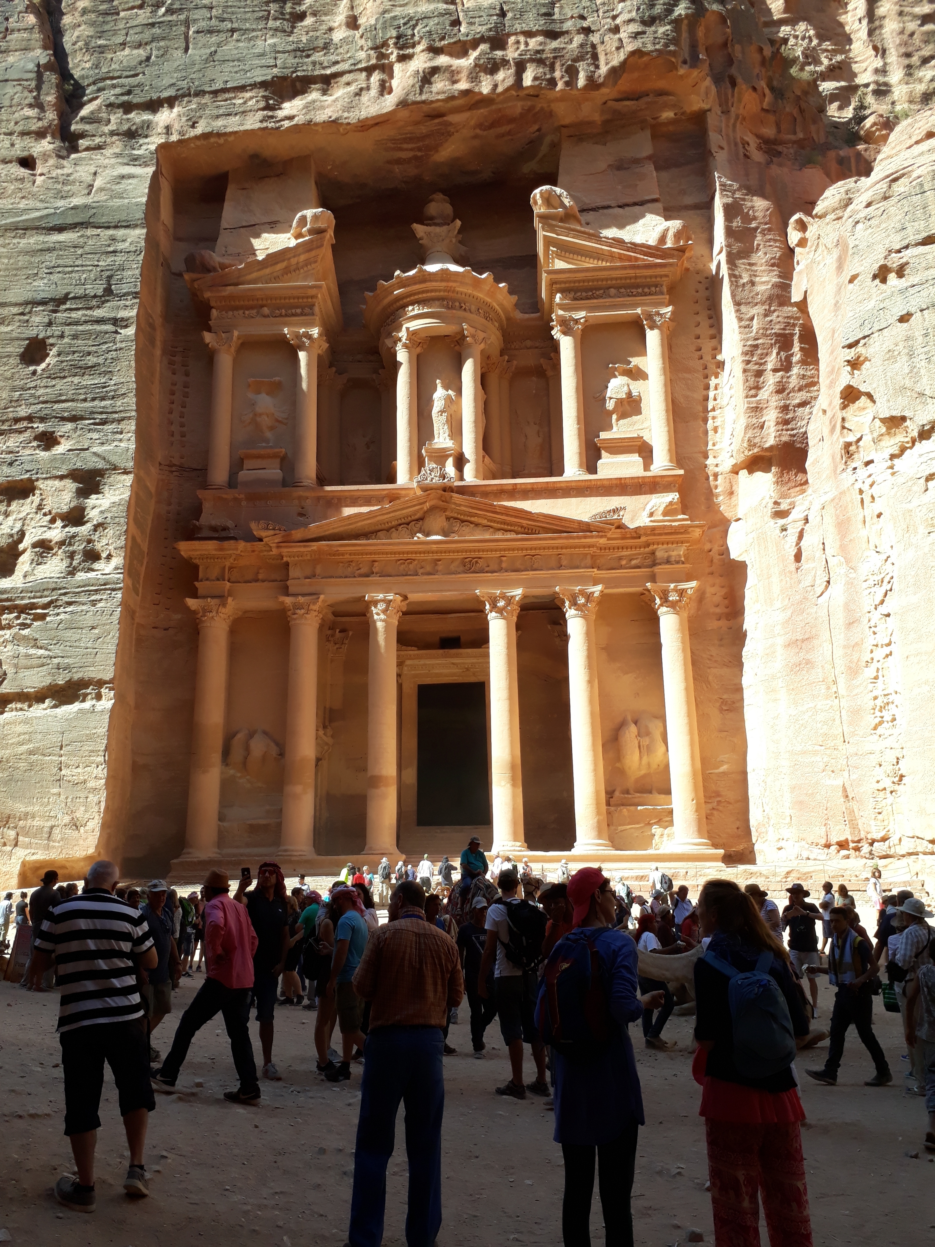 Petra Treasury with tourists at the base of the facade.