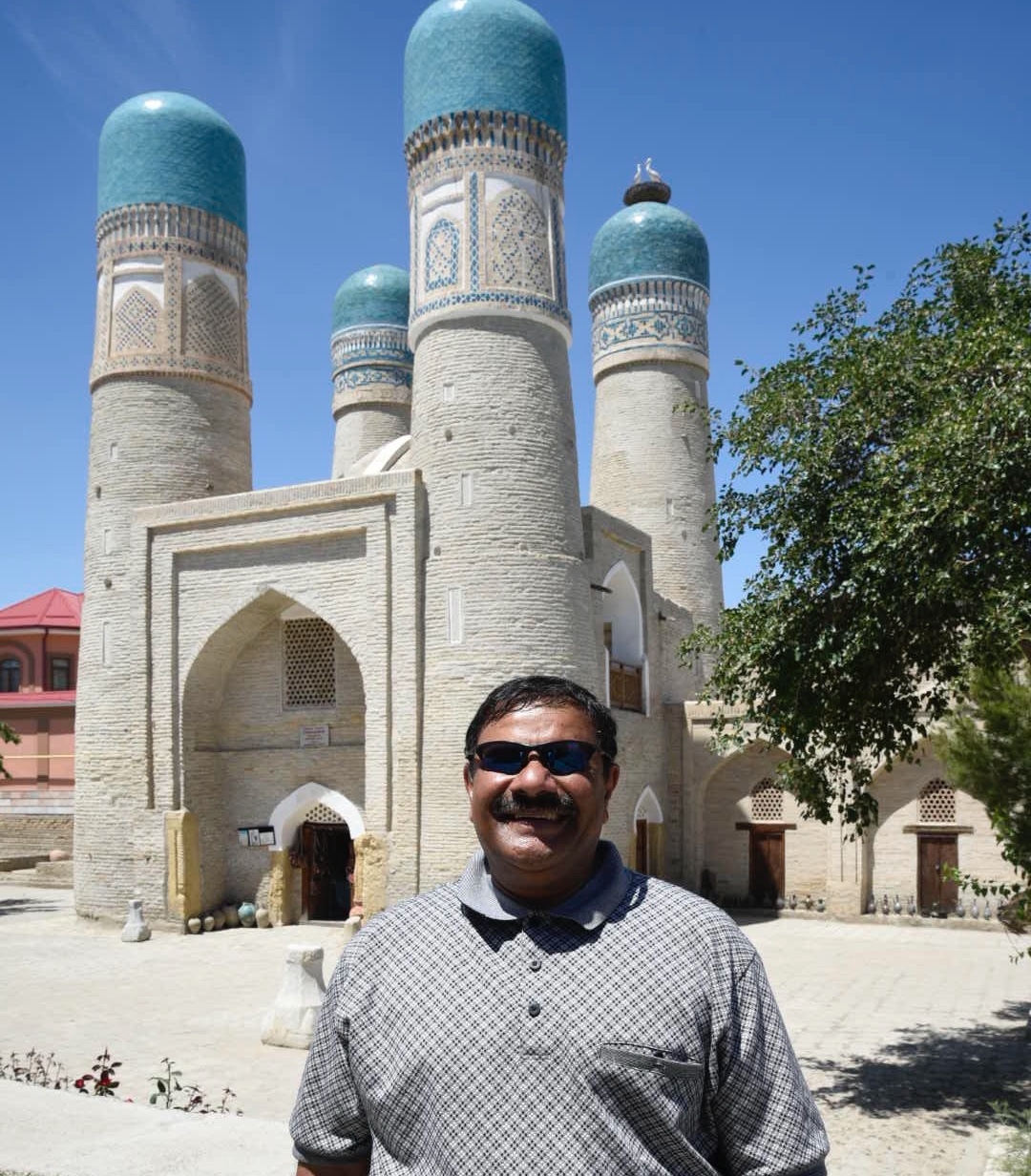 Person in front of a historical building with minarets.