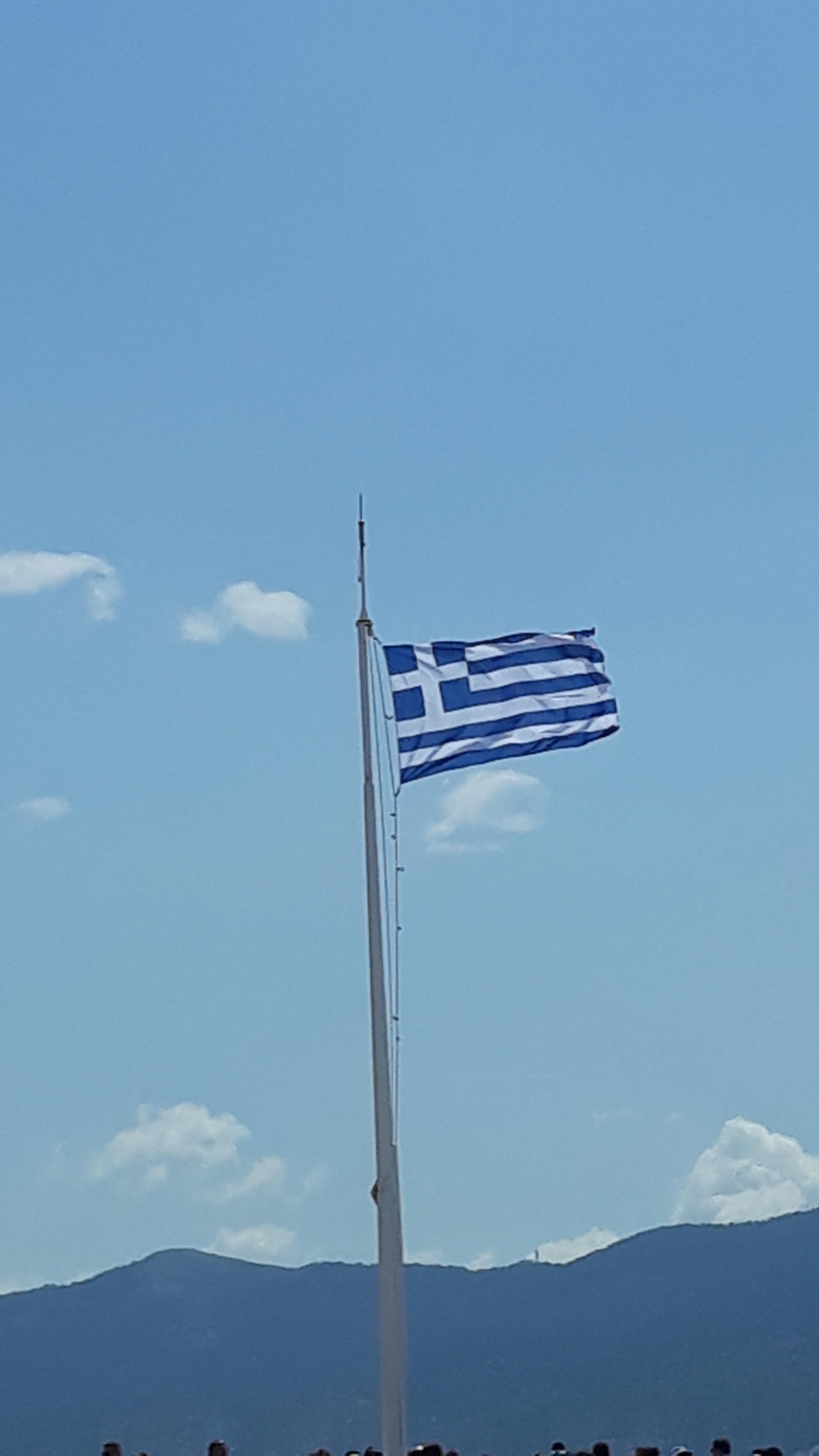 Greek flag waving against a blue sky.