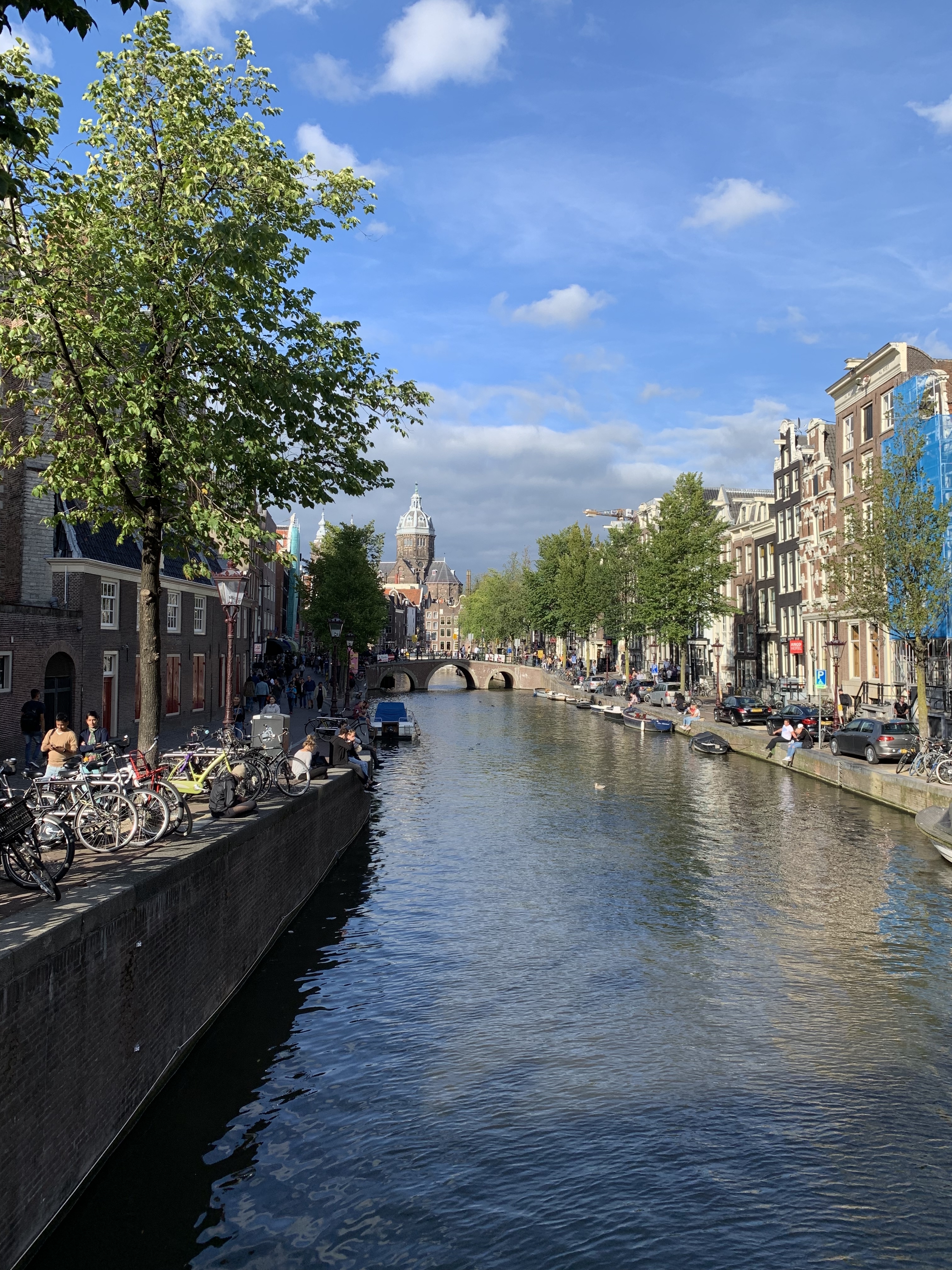 Picturesque canal with a large church and boats on a sunny day.