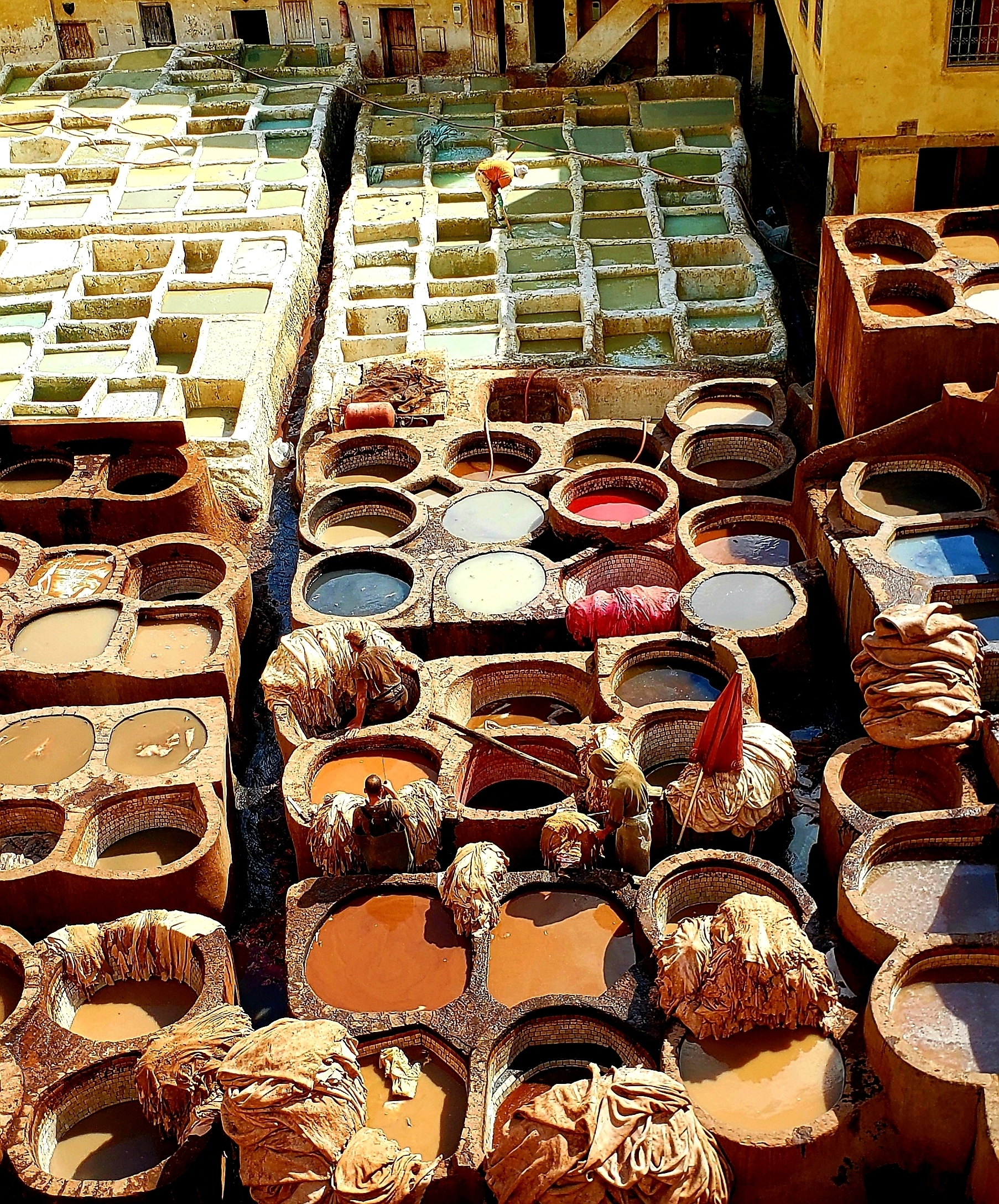 A vibrant image of traditional dye vats used for leather tanning.