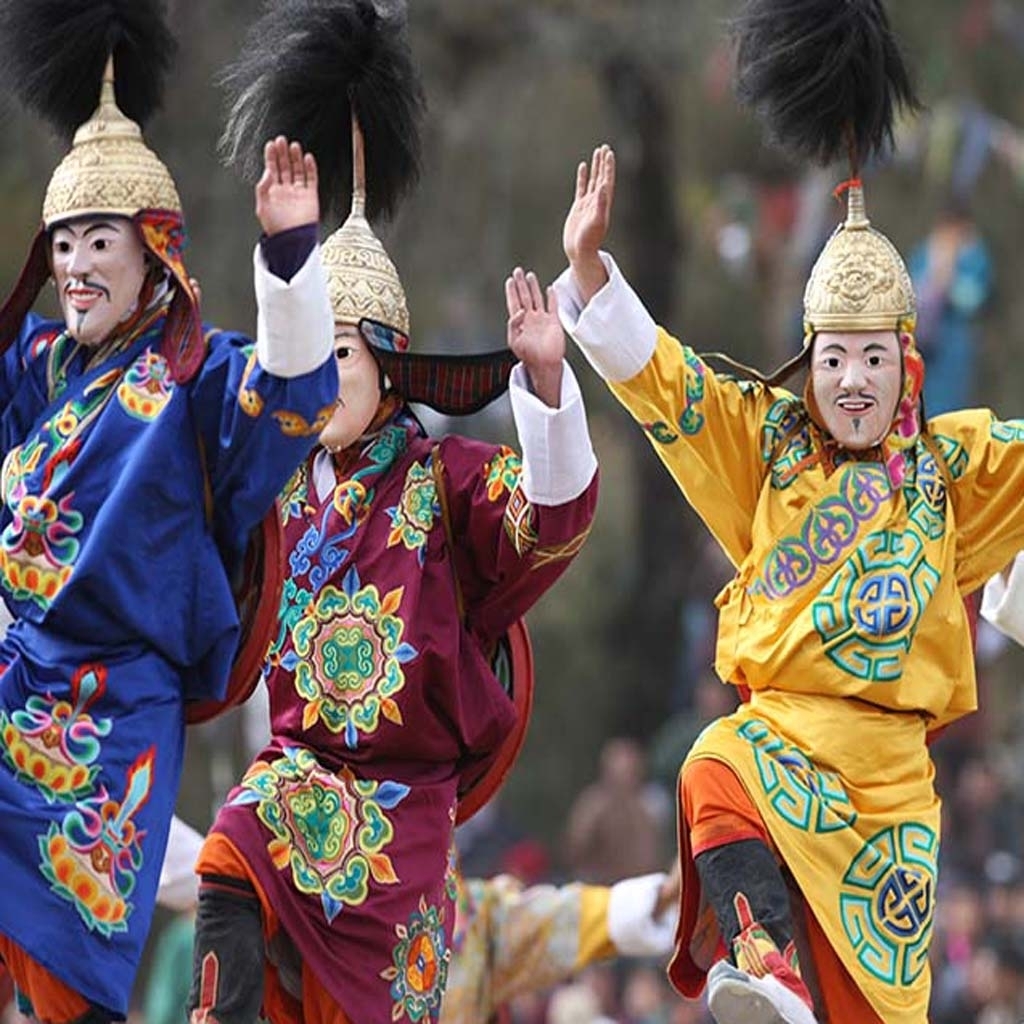 Traditional performers in colorful costumes and masks during a cultural dance.