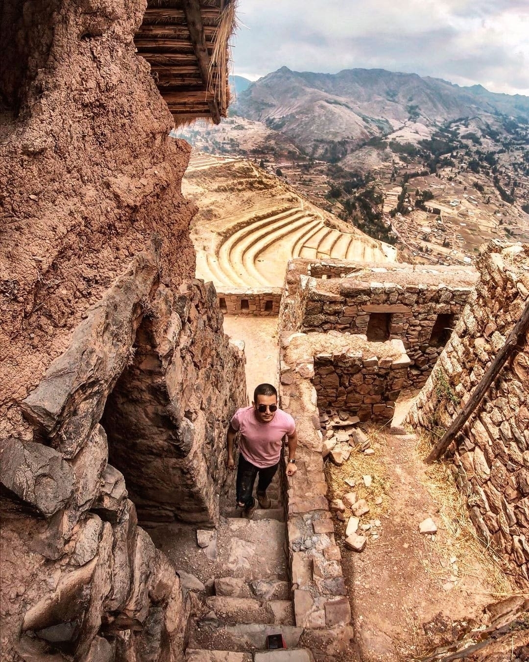 Person standing amidst ancient stone ruins.
