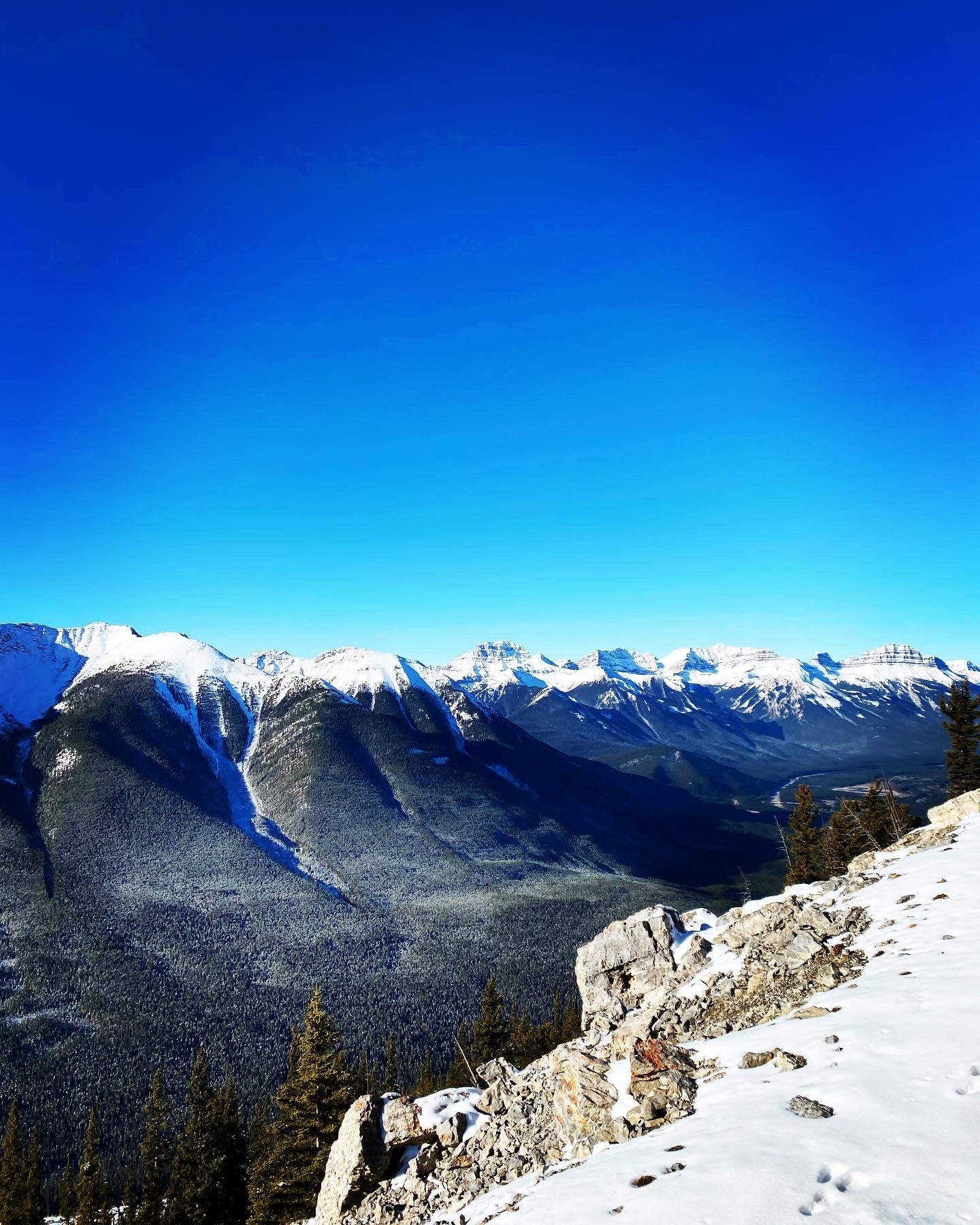 Panoramic view of snow-capped mountains under a clear blue sky.