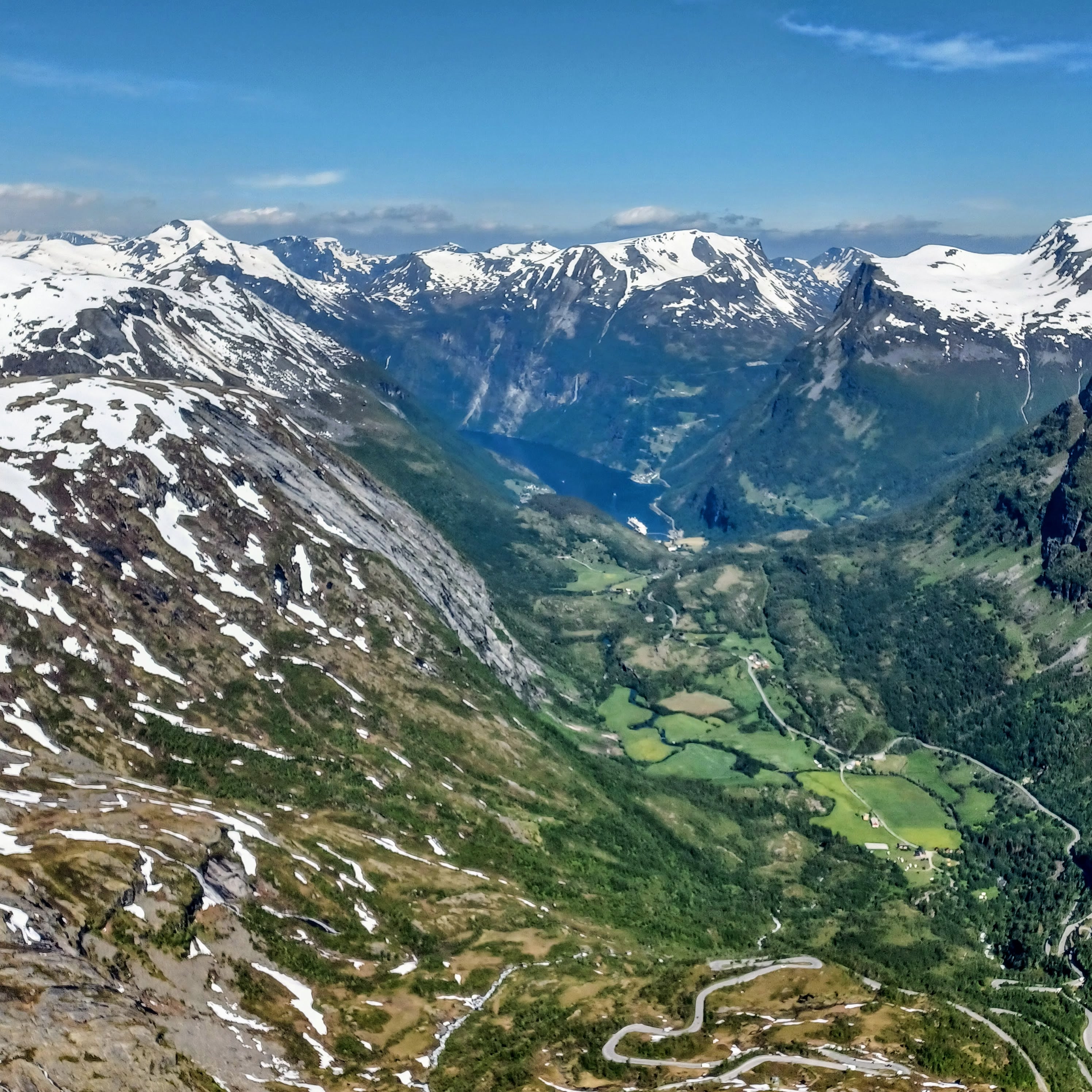 A breathtaking view from a high altitude of snow-capped mountains and a valley.