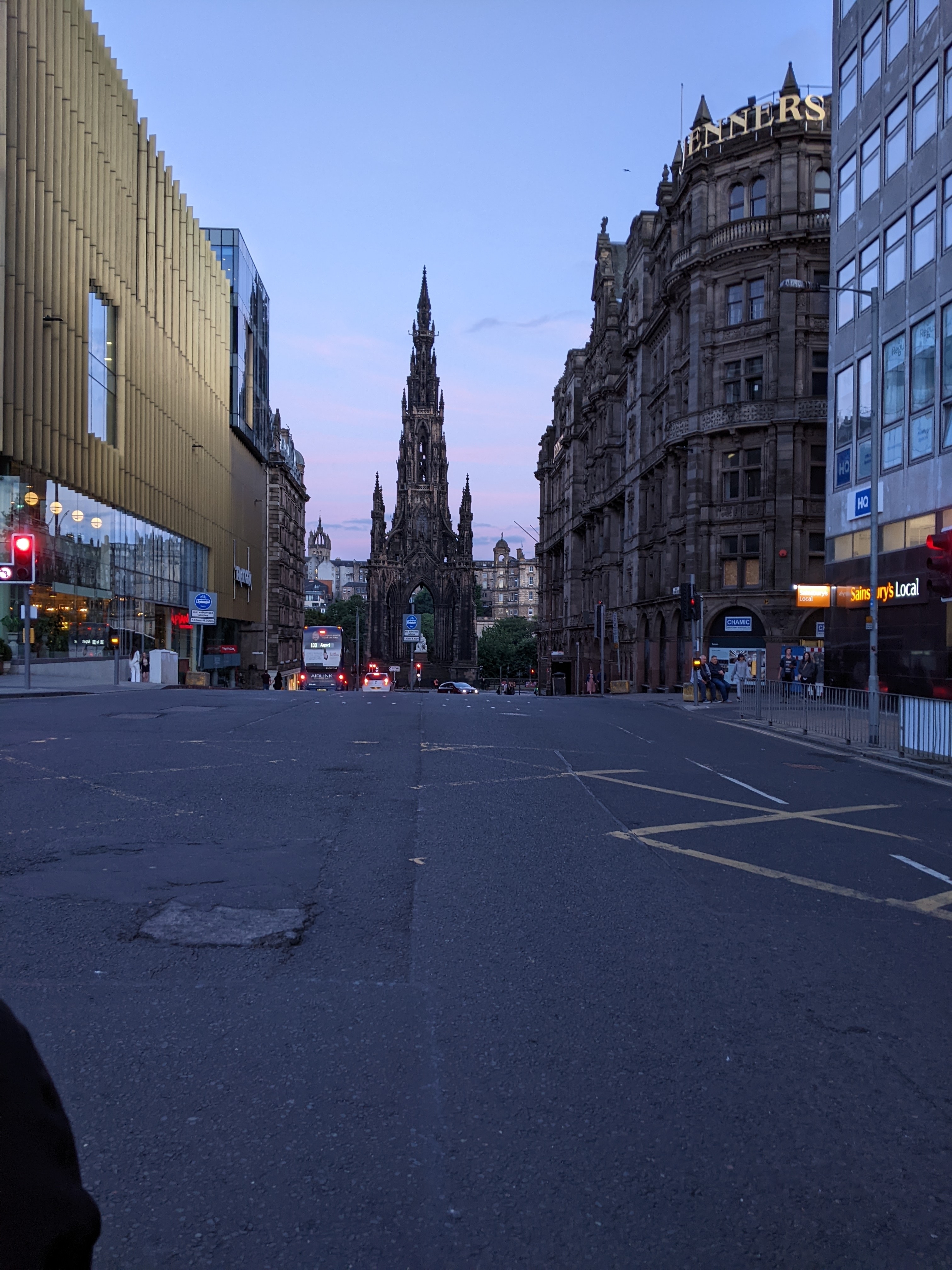Street view with historic buildings and a monument.