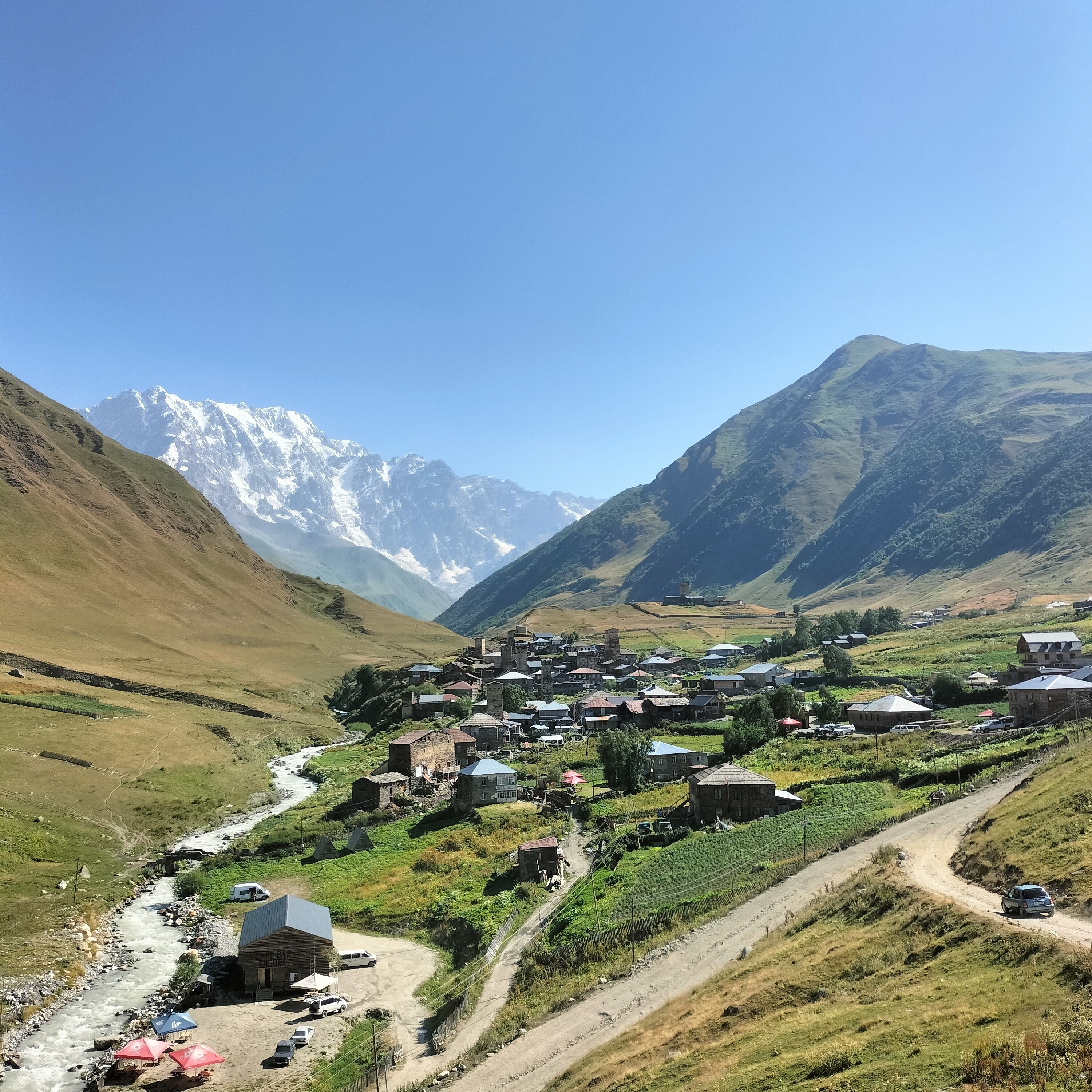 Village nestled in a mountainous region with snow-capped peaks.