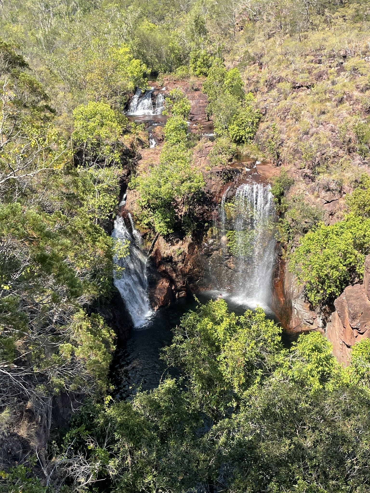 Aerial view of waterfalls surrounded by lush greenery.