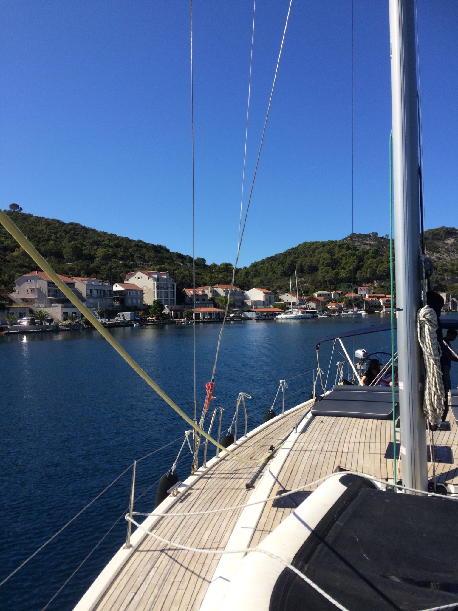 Coastal village with boats docked in a harbor under a clear sky.