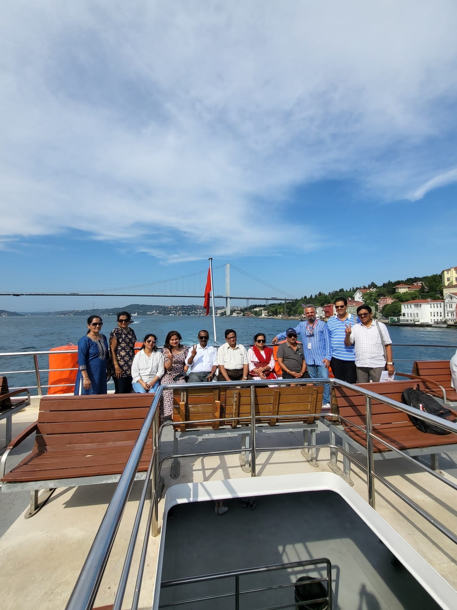 People enjoying a boat ride with a large bridge in the background.