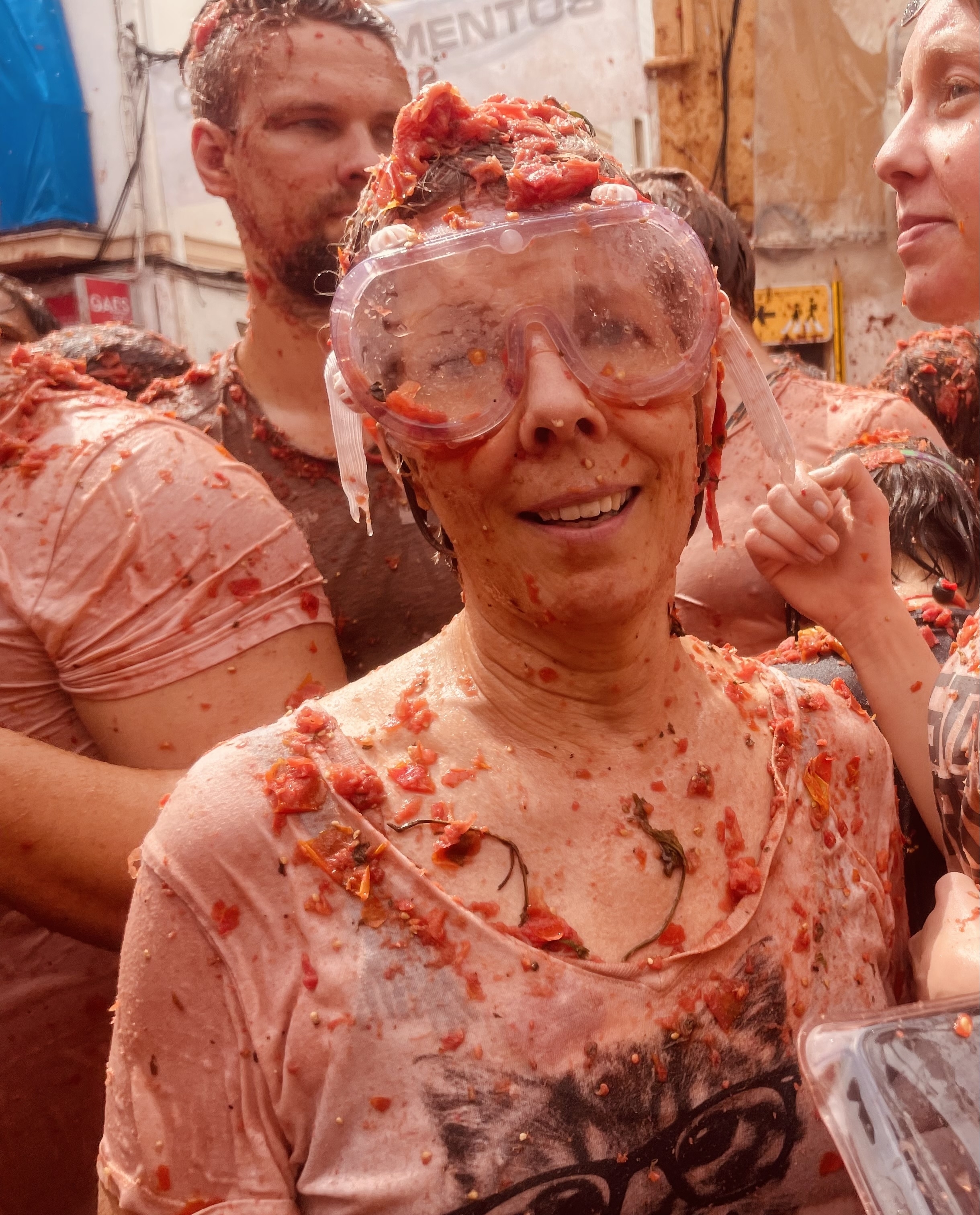 People participating in a tomato festival, covered in tomatoes.