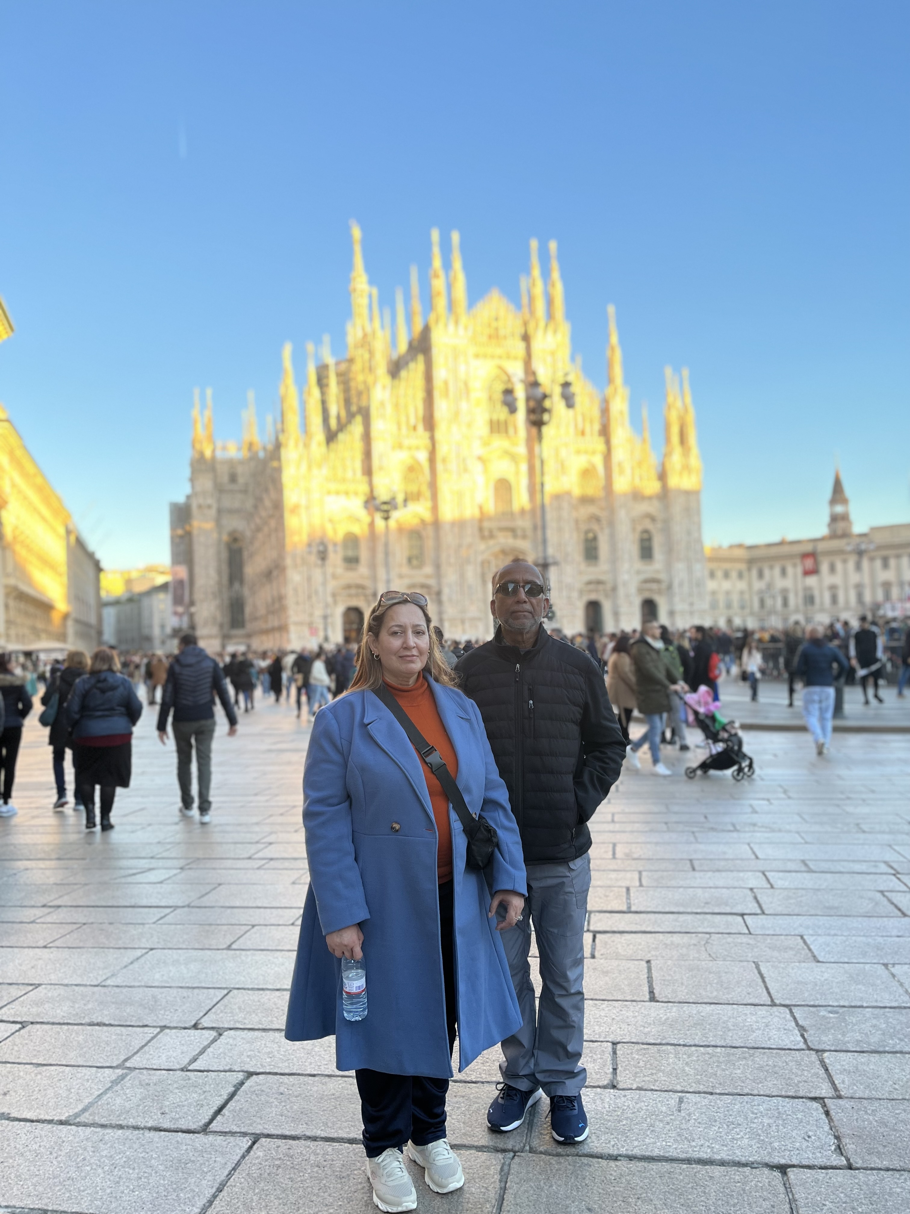 Two people in warm clothing in front of Milan Cathedral.