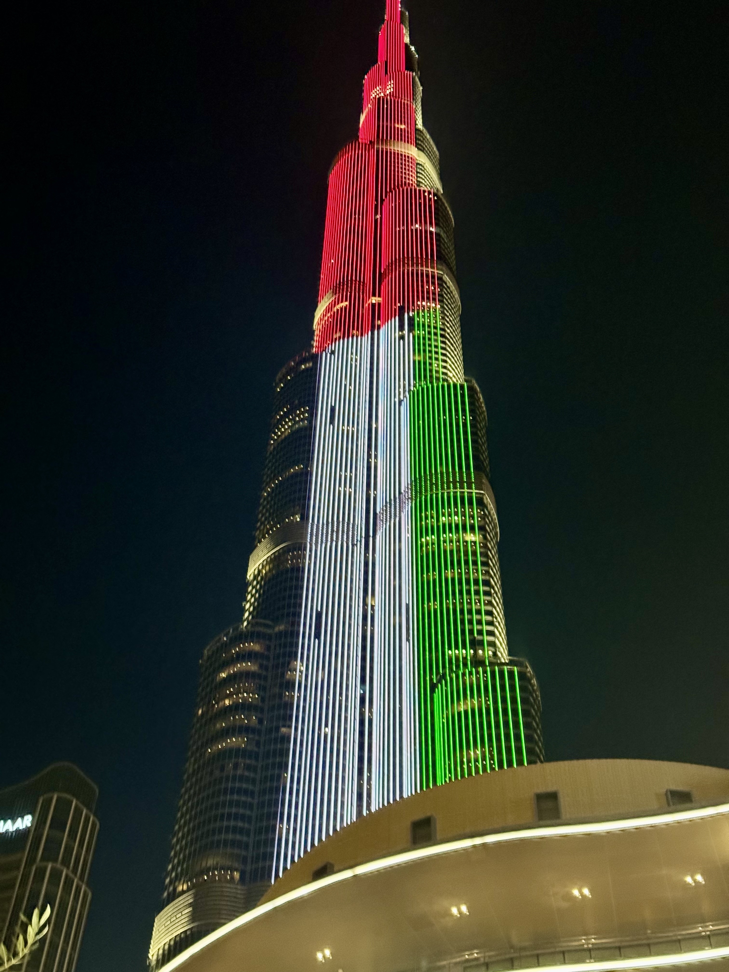 Skyscraper illuminated with colored lights.