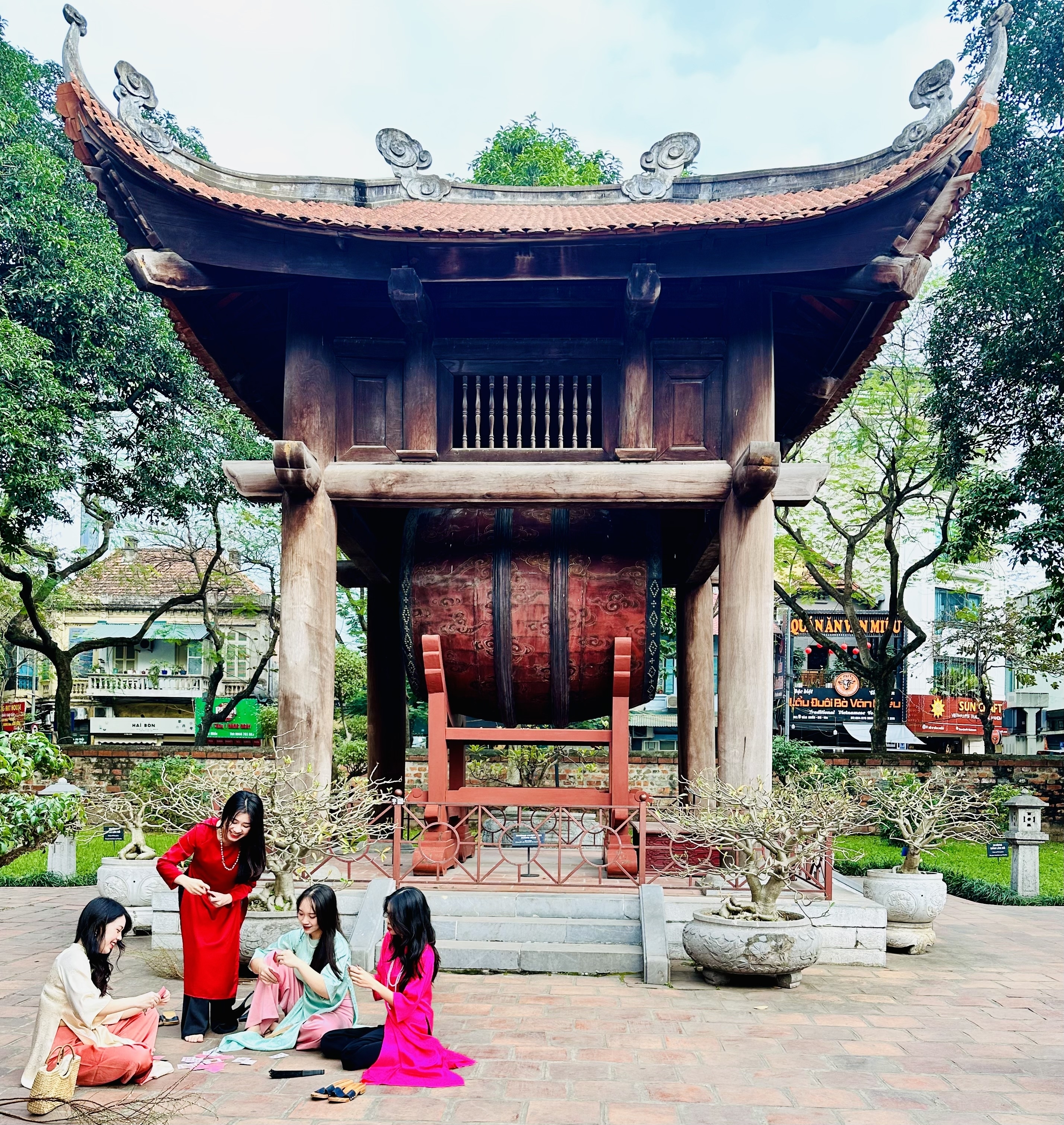 Woman posing in front of an ancient temple with a large drum.