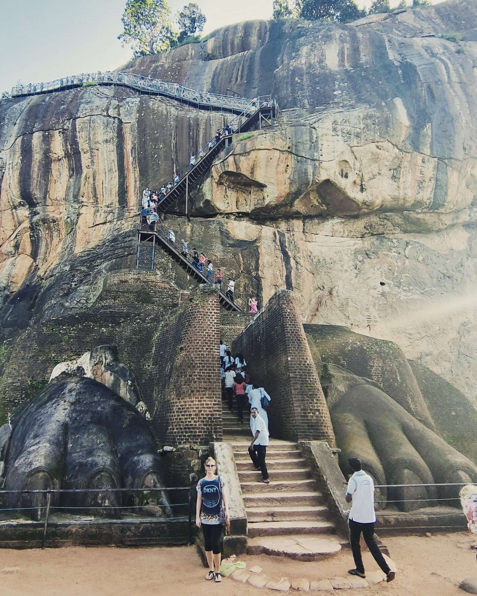 Crowds climbing stairs on a rocky formation.