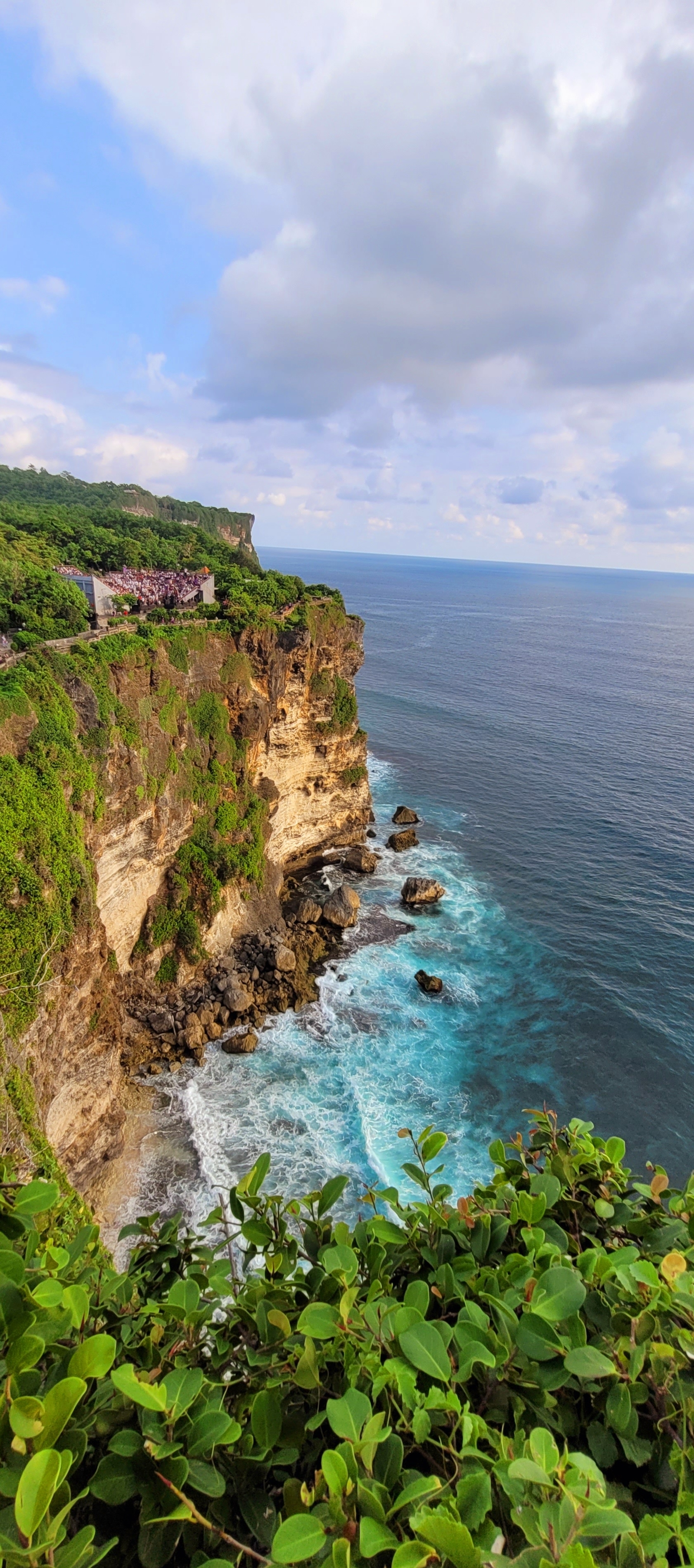 A dramatic cliff with waves crashing against the rocks below.