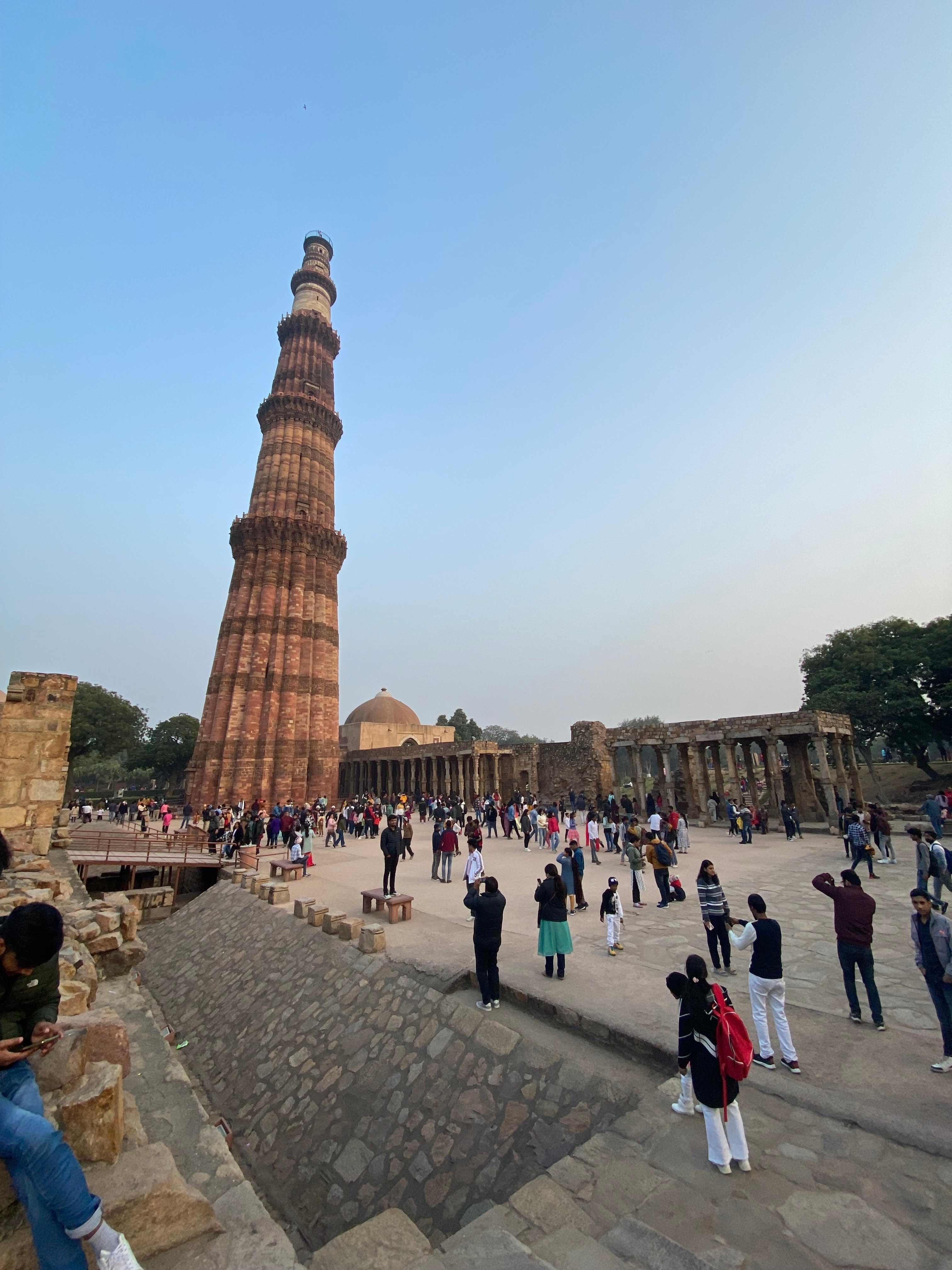 Crowd of people around a tall historic tower.