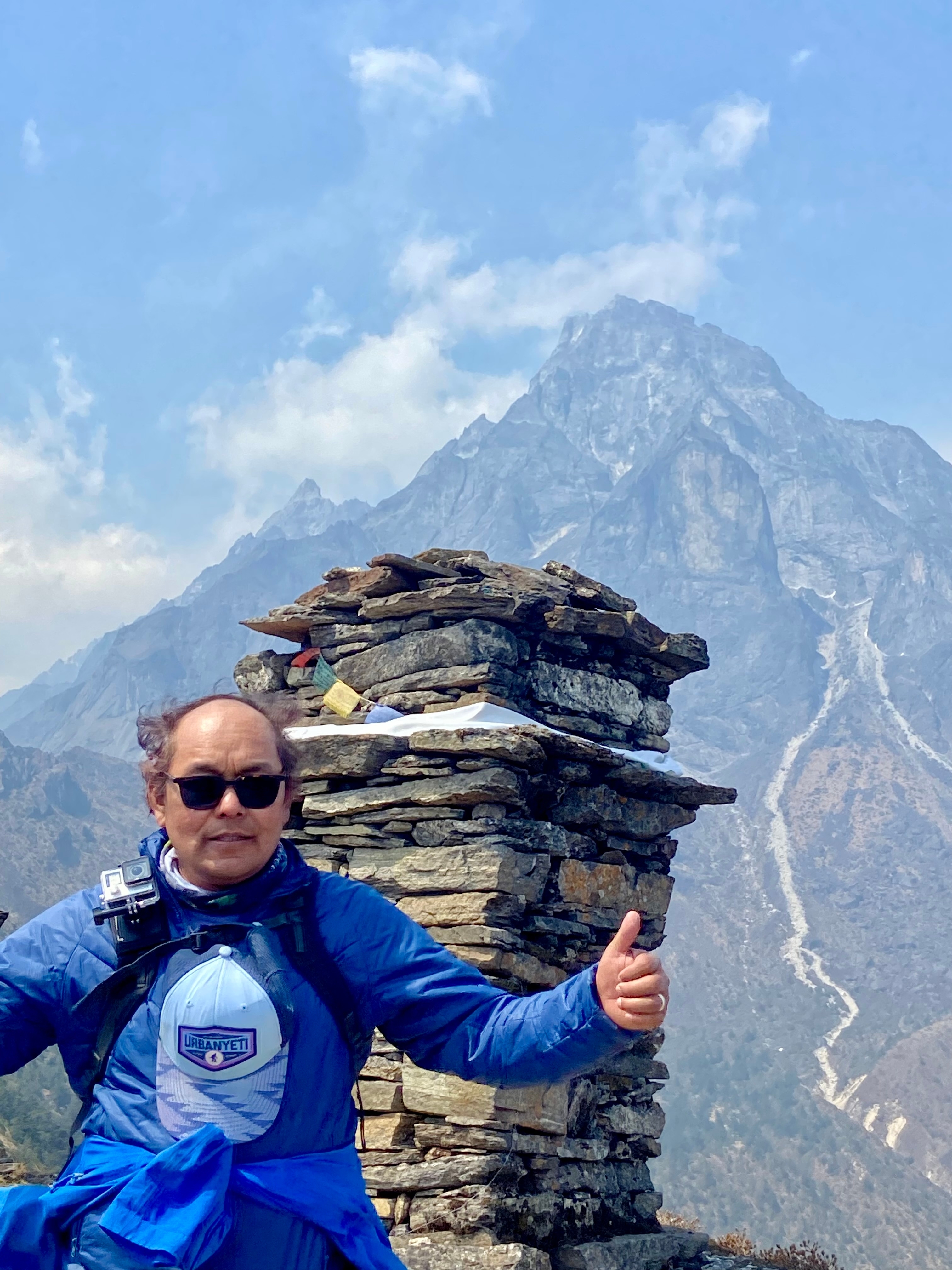 Person posing with a backdrop of mountains.