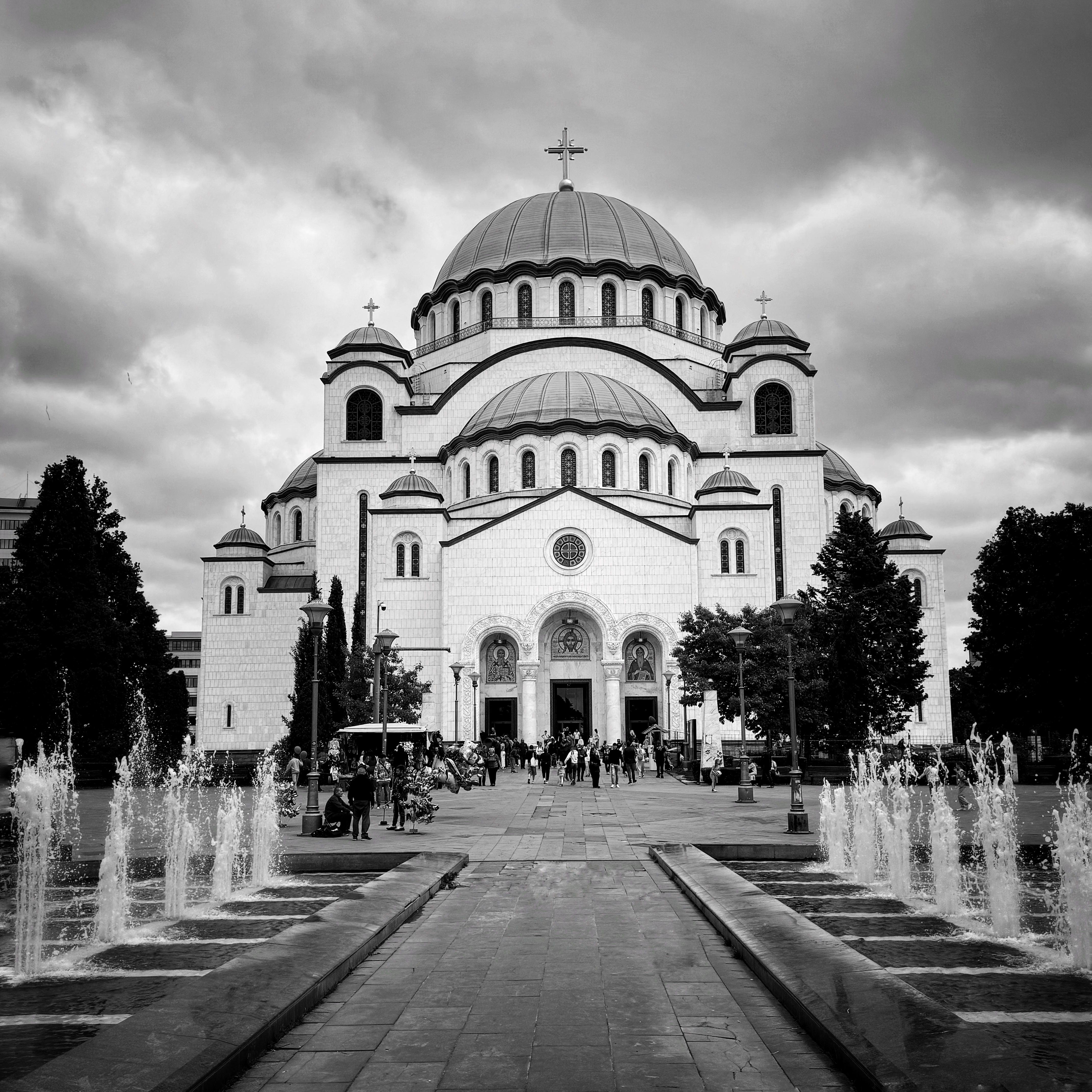 Large white cathedral with multiple domes and fountains in the foreground.