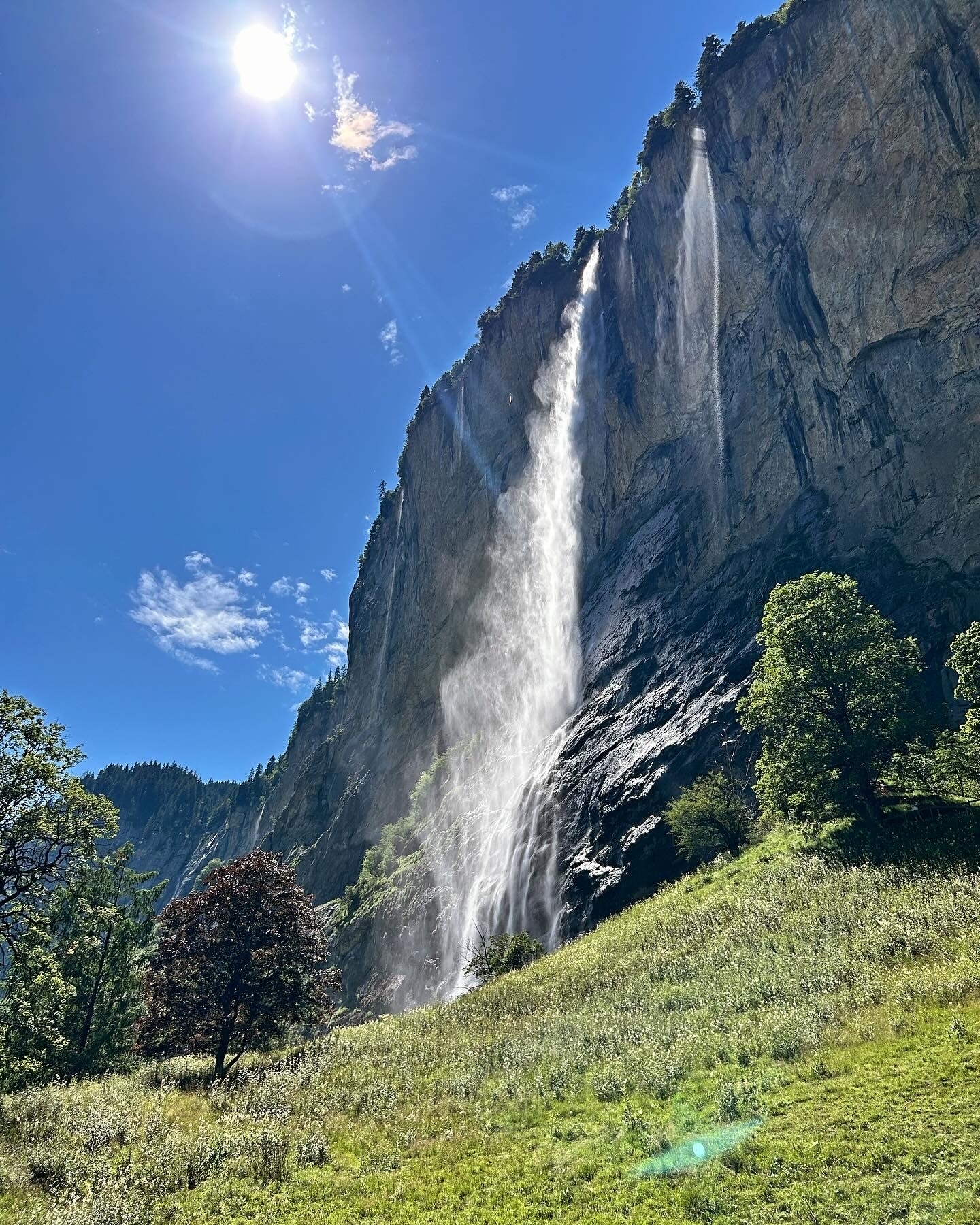 Dramatic waterfall cascading down a rocky cliff with lush greenery.