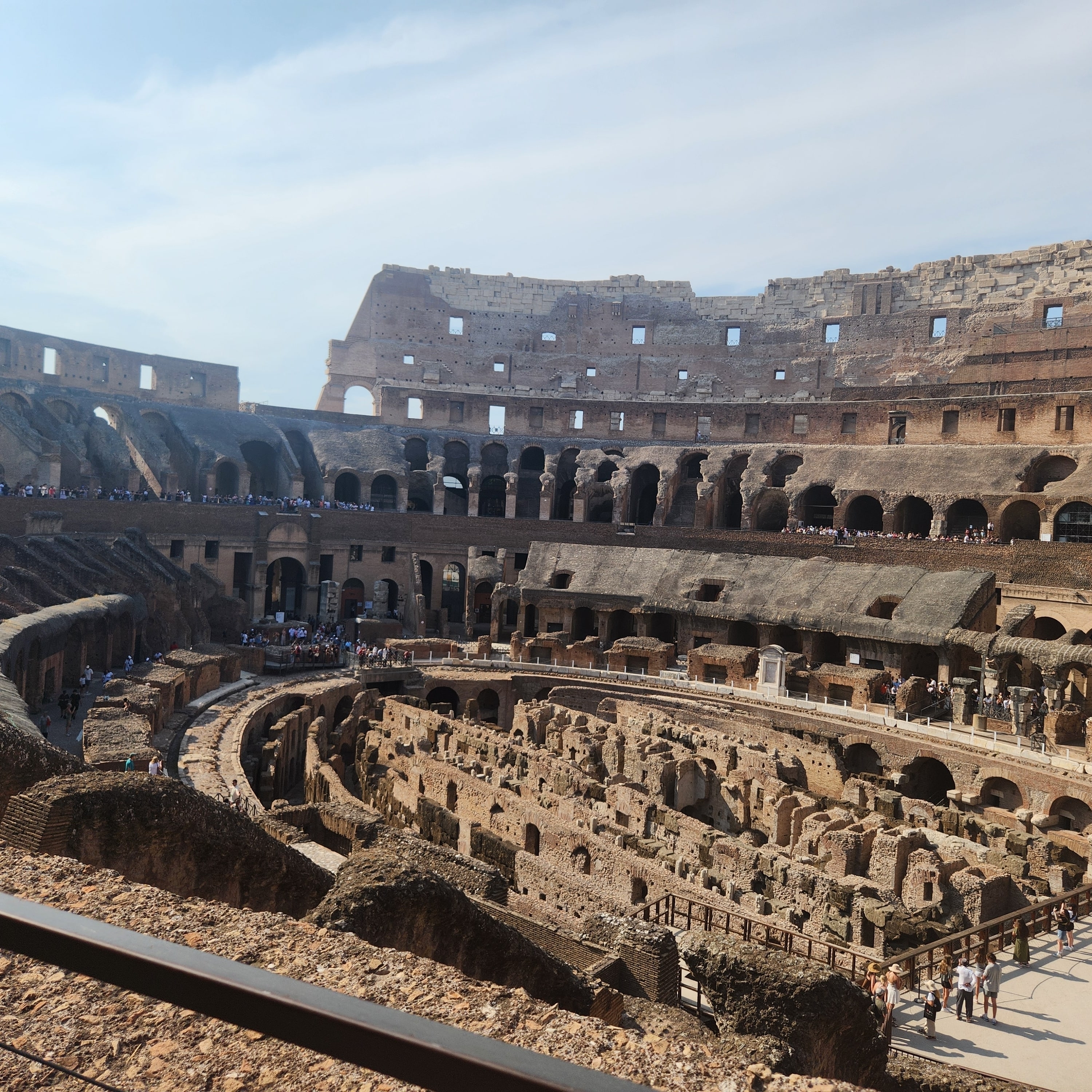 Interior view of the Colosseum filled with tourists.