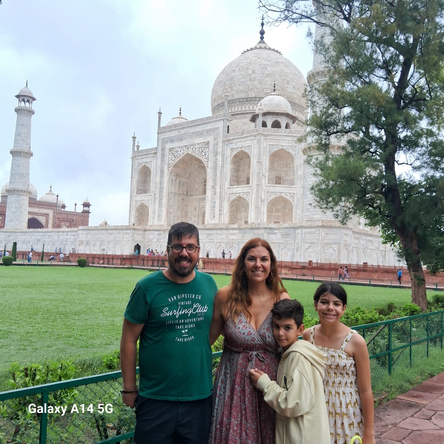 Family posing in front of the Taj Mahal.