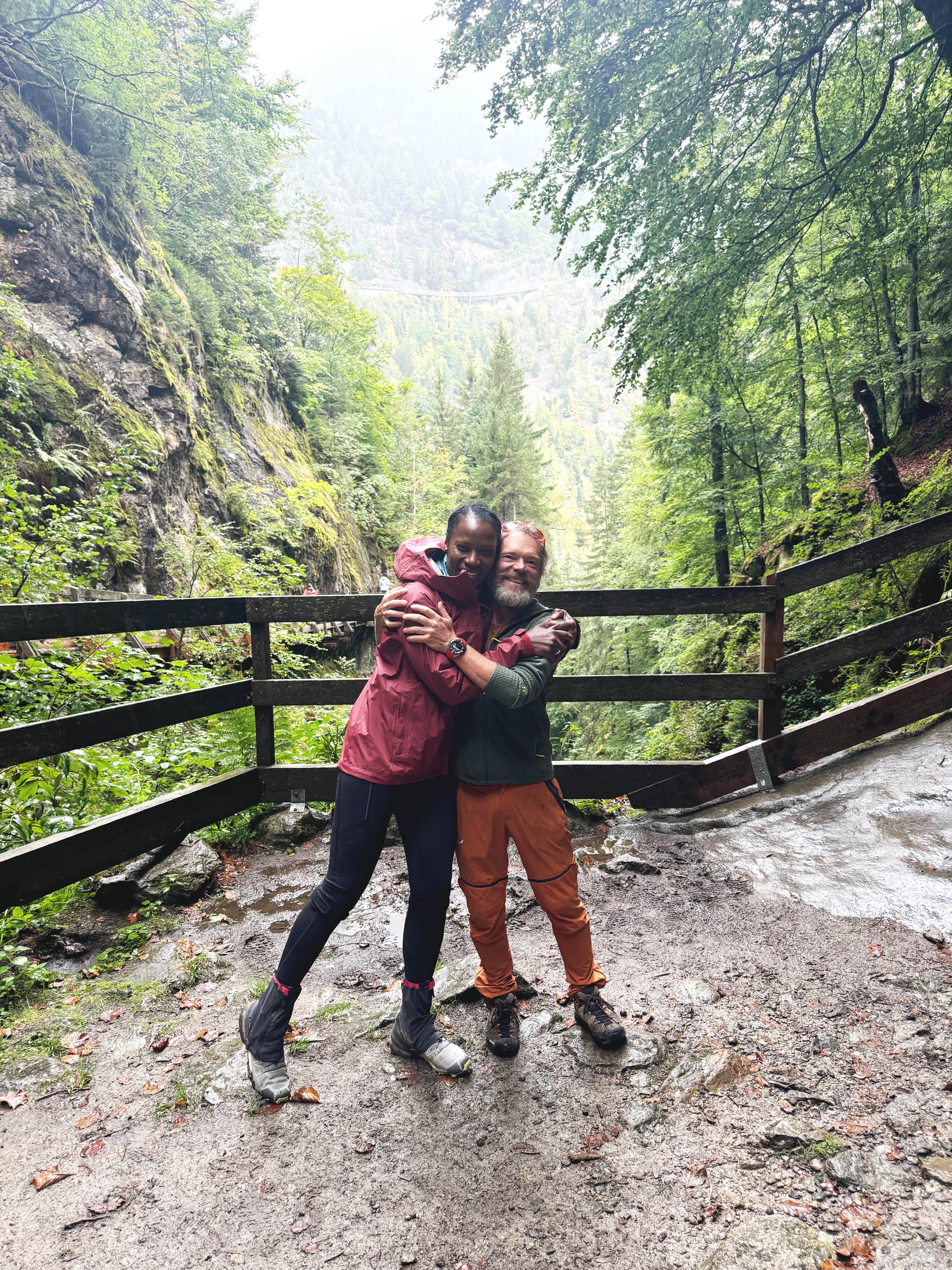 Happy couple embracing in a lush green forest.