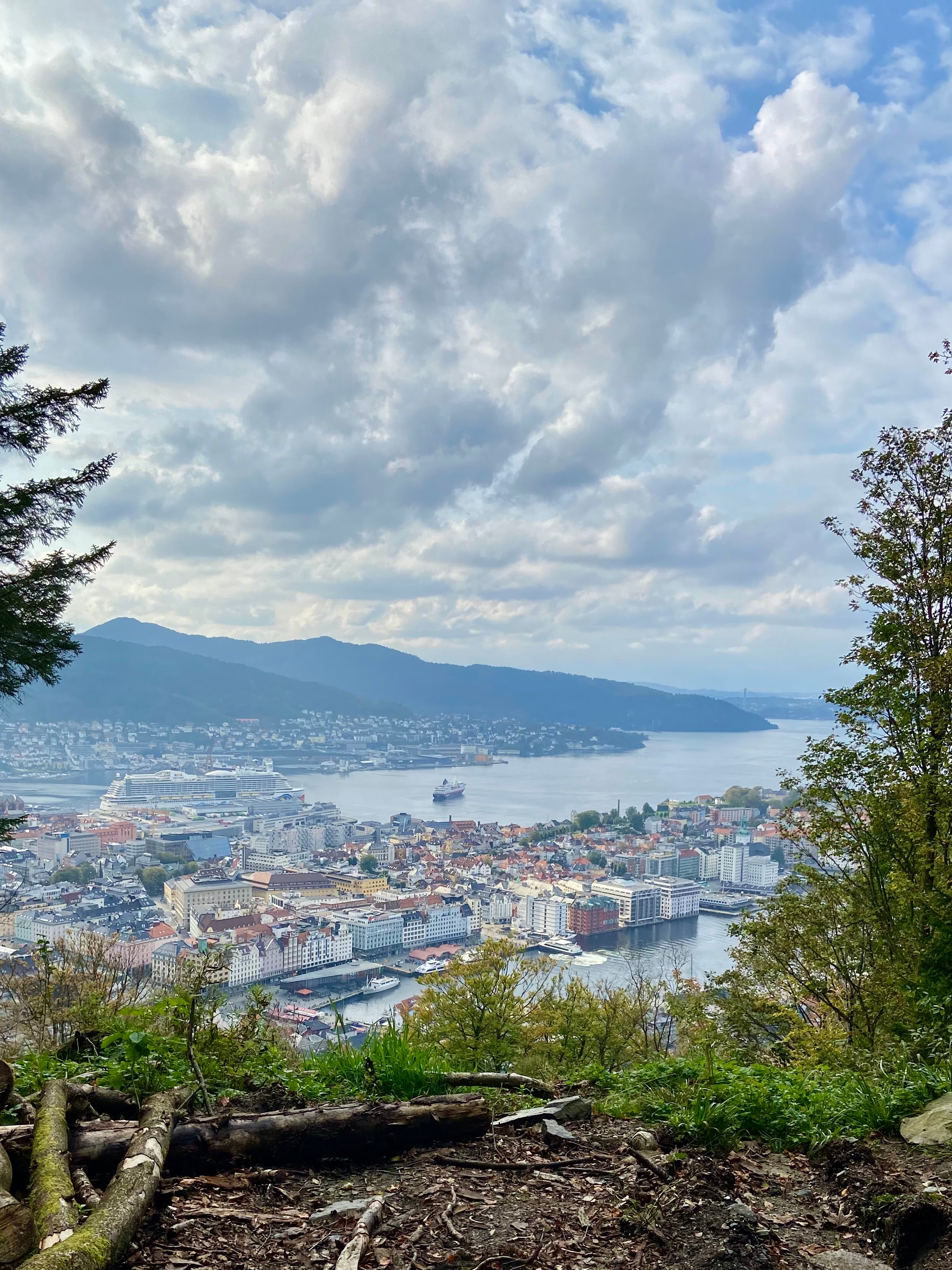 Overlooking a city and harbor with surrounding mountains.