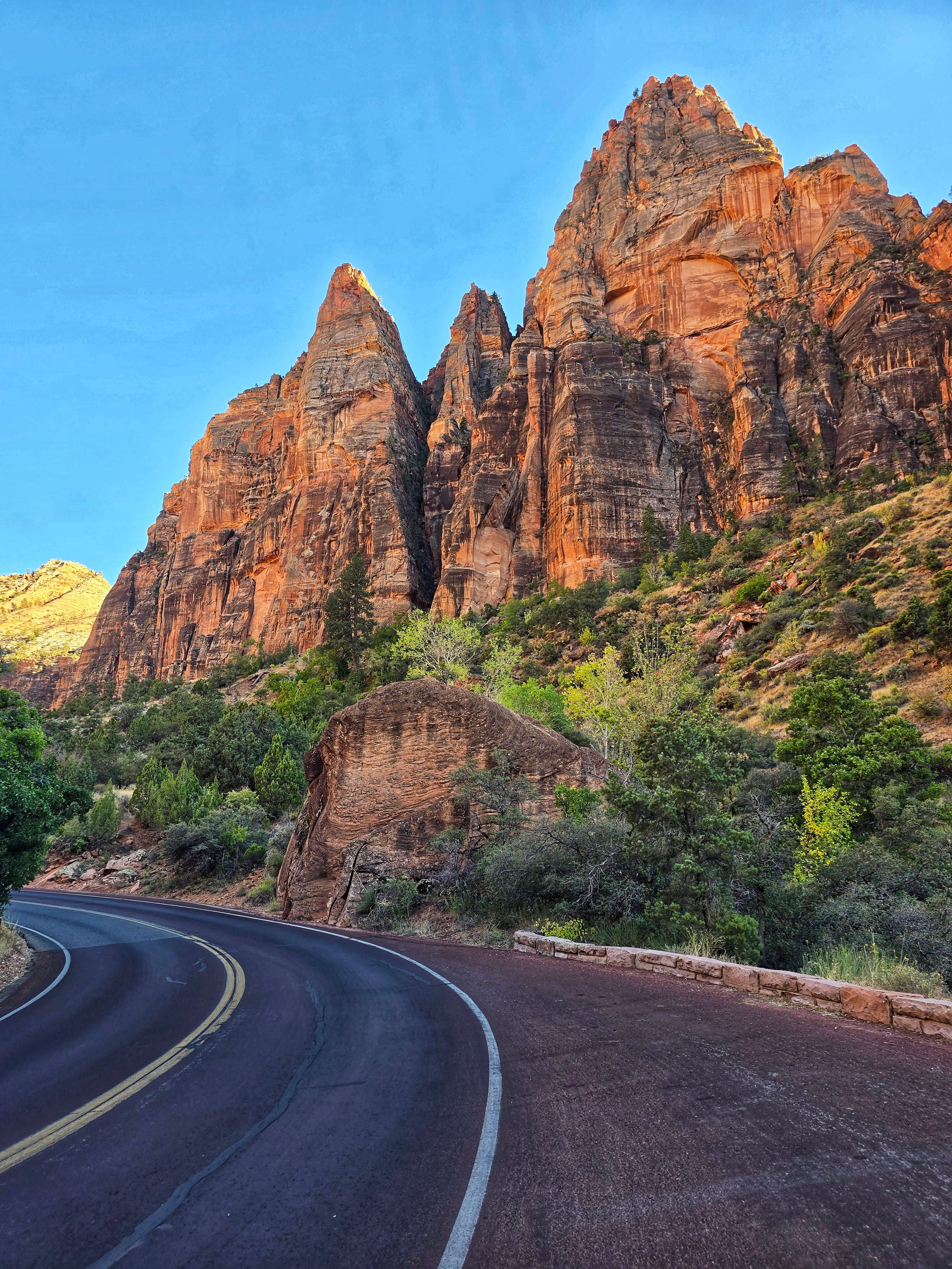 Scenic view of red rock cliffs and green foliage