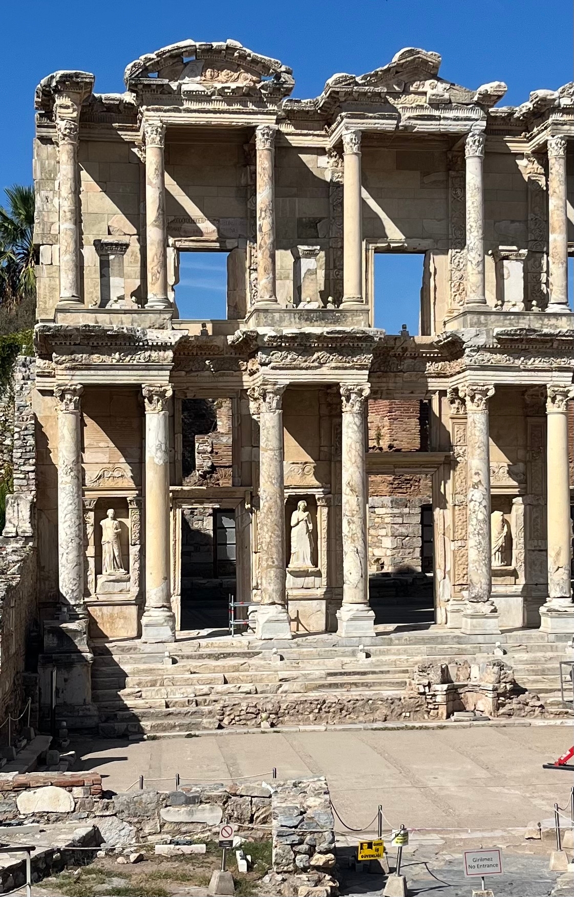 Ancient Roman library ruins with statues.