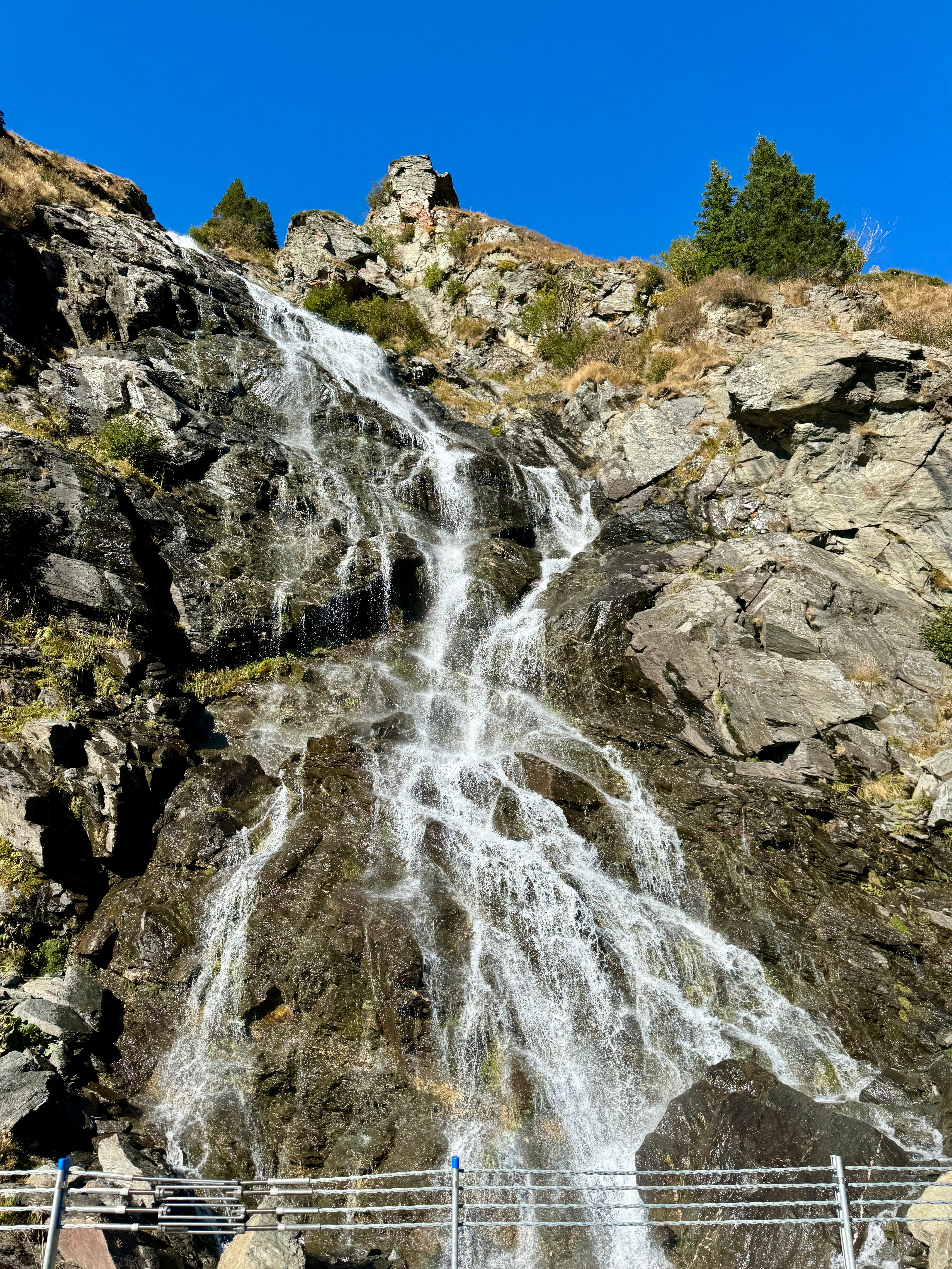 Waterfall cascading over rocky cliffs in a natural setting.
