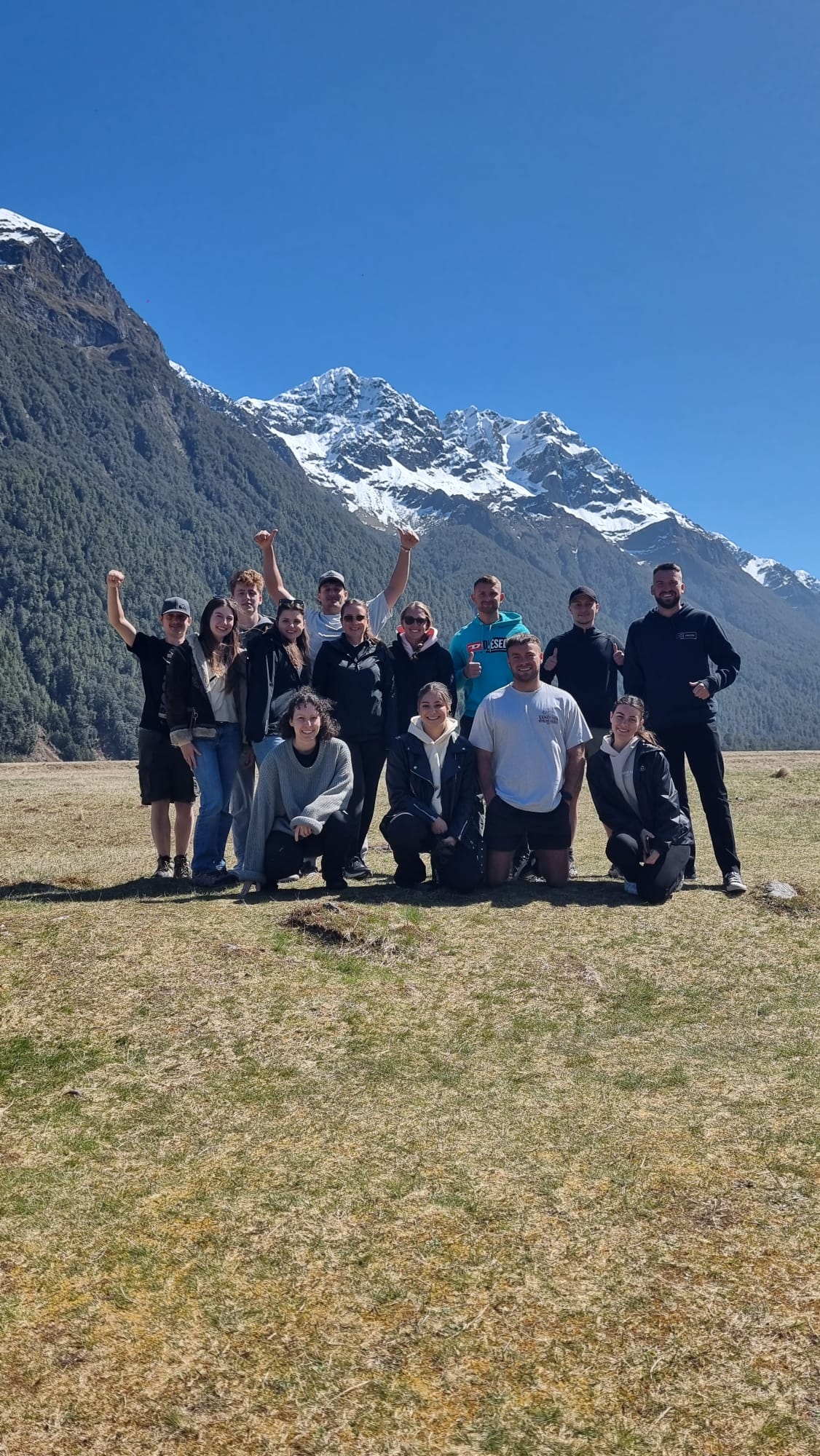Group of people celebrating with a scenic mountain view.