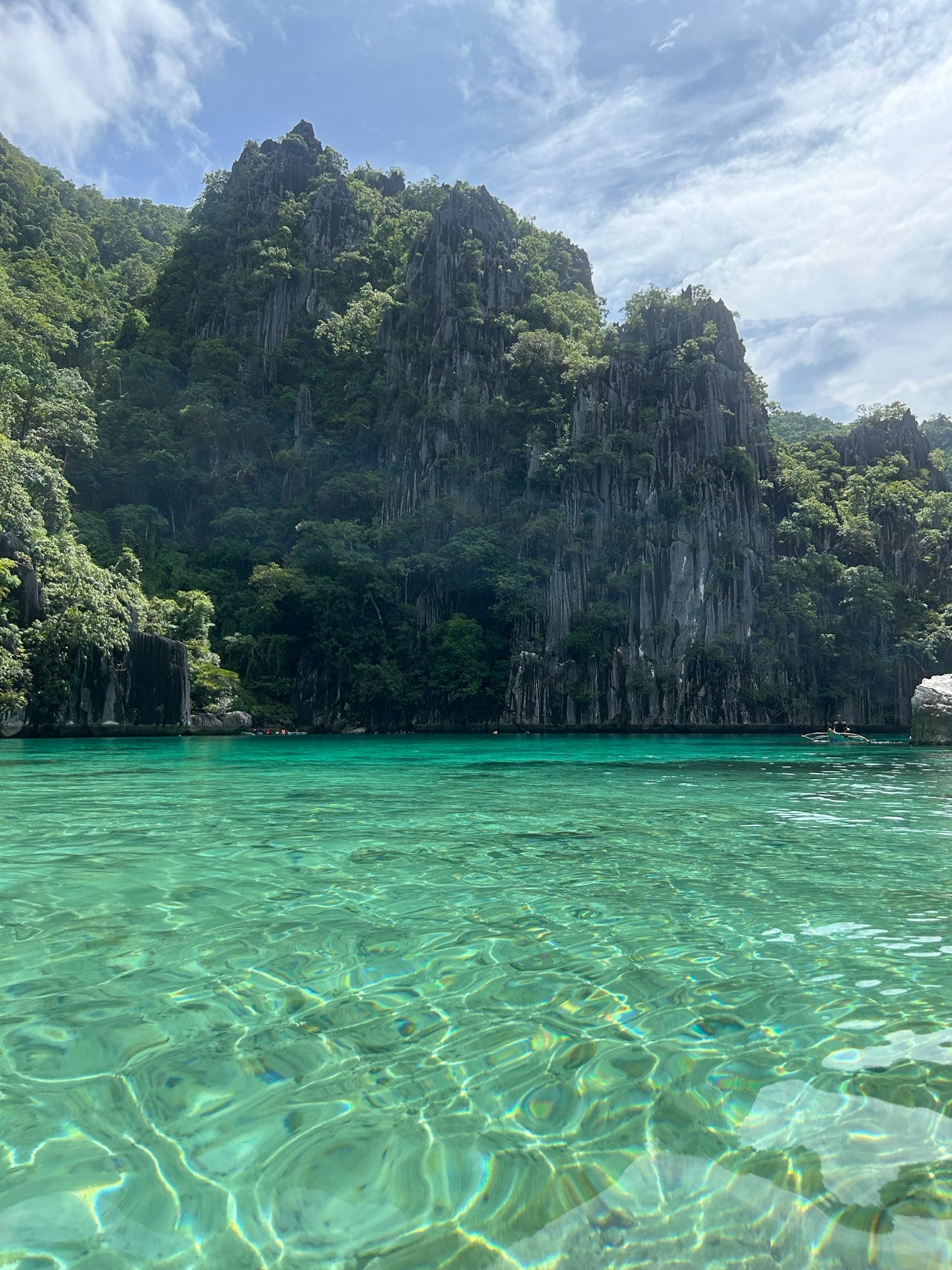 Turquoise water in a lagoon surrounded by tall cliffs.