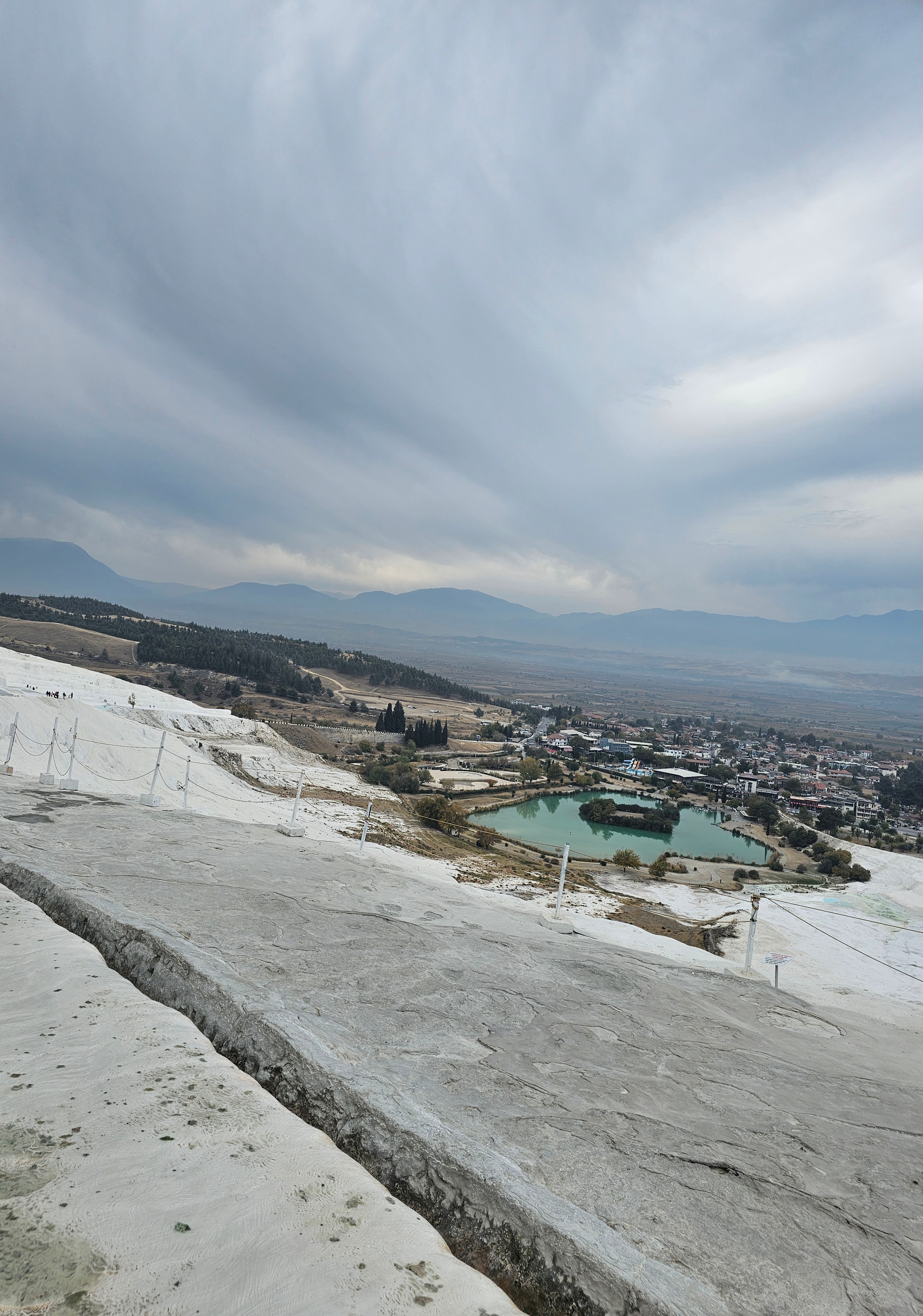 Pamukkale landscape with thermal pools and distant mountains.