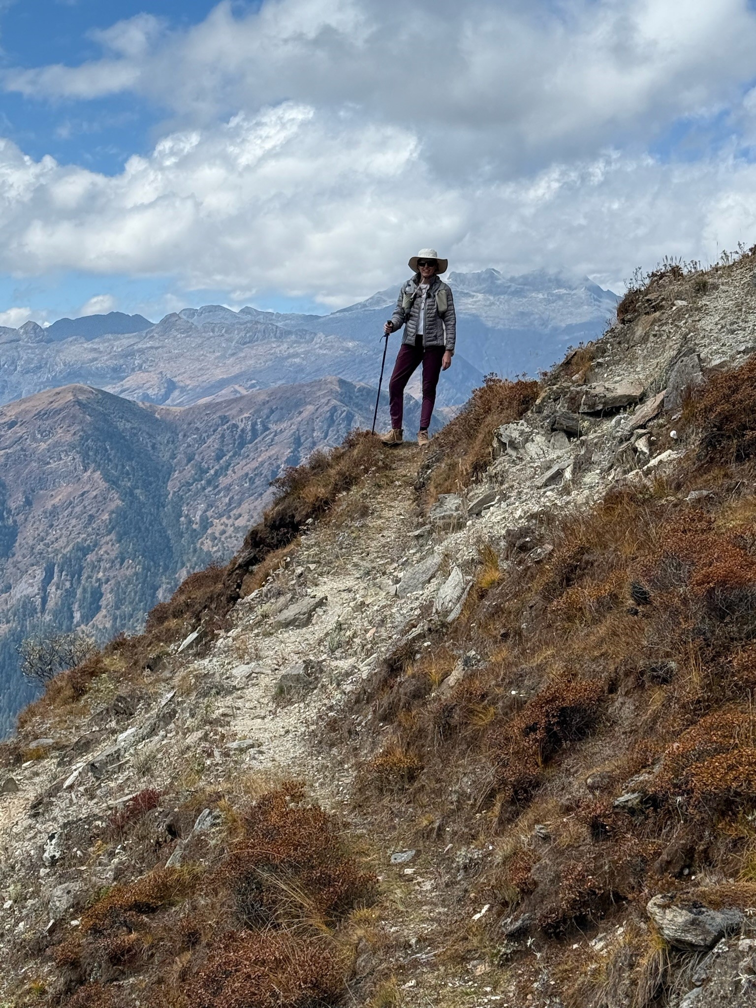 A person hiking on a mountain trail with expansive views.
