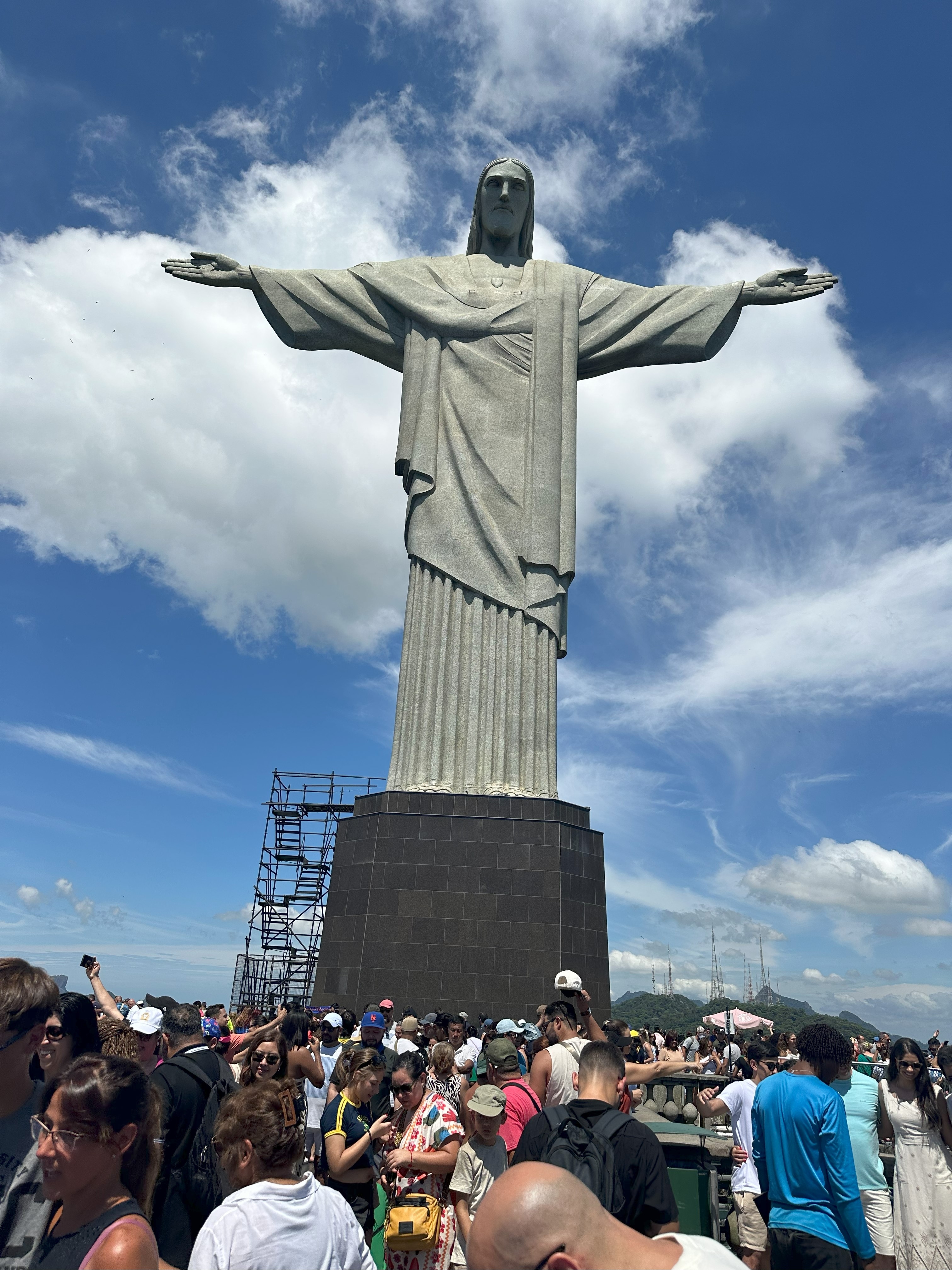 Partial view of a large statue against a clear sky.
