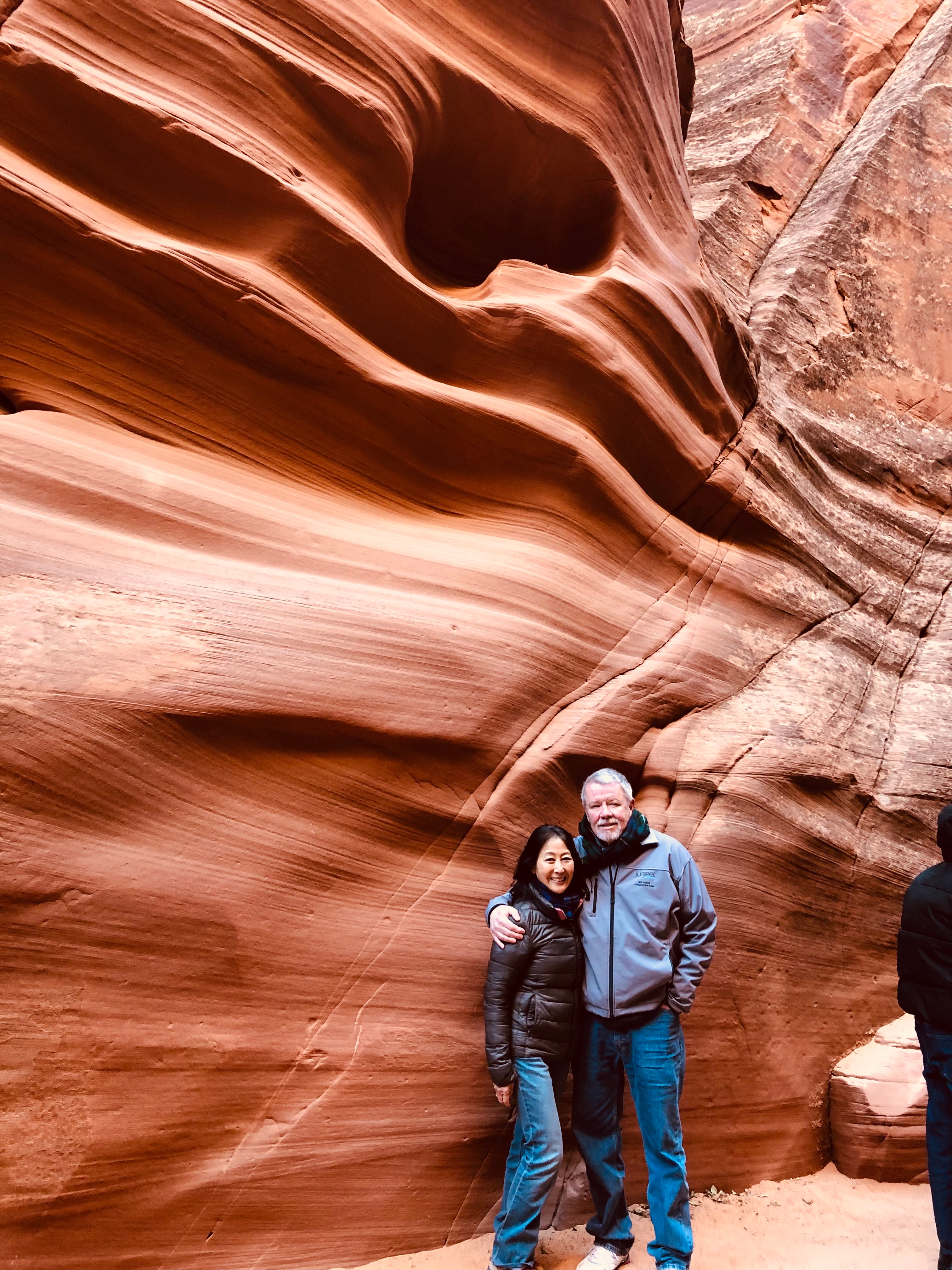 Couple posing in front of red sandstone formations.