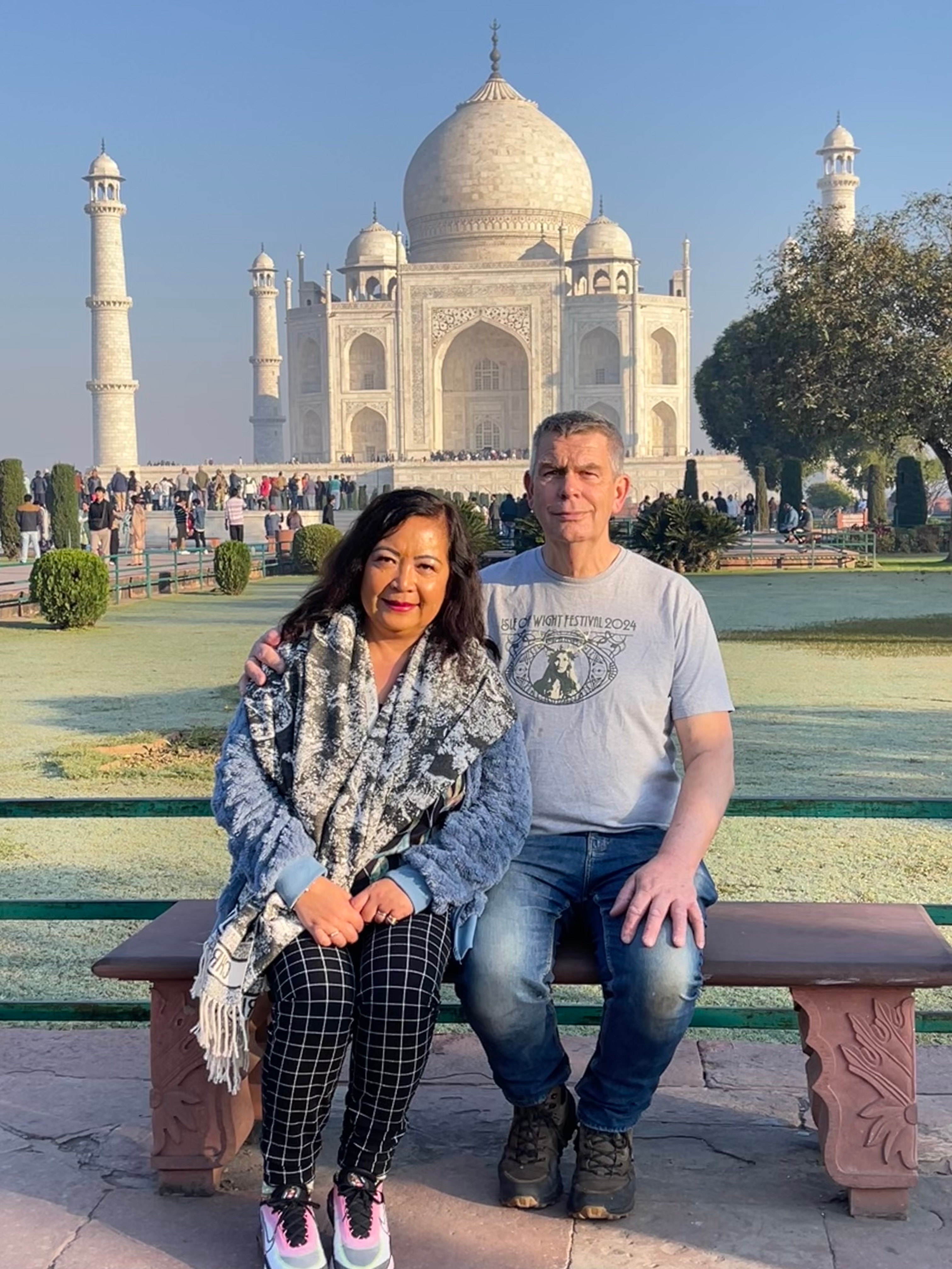 Couple sitting in front of the Taj Mahal.
