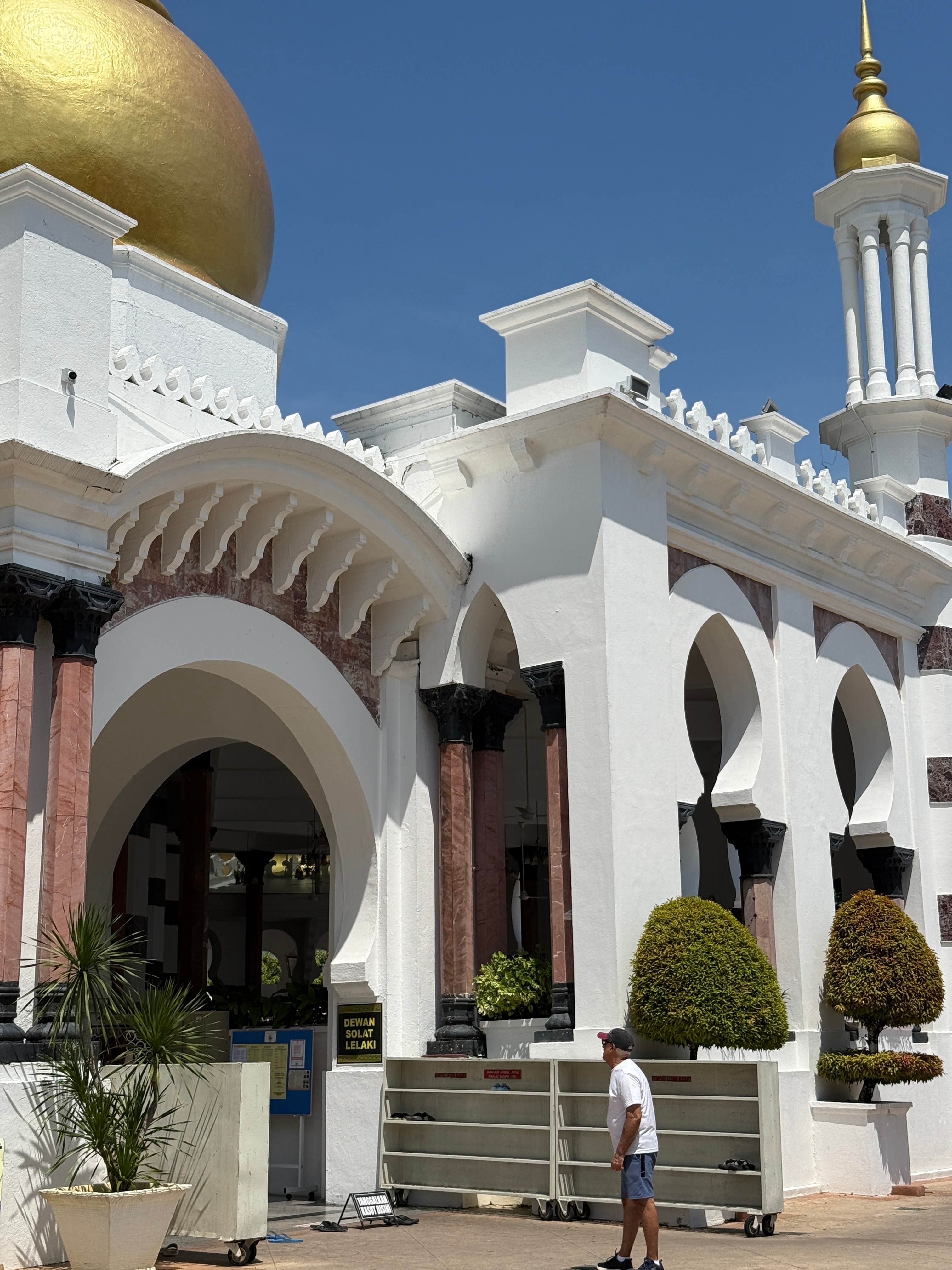 White building with arches and intricate detailing.