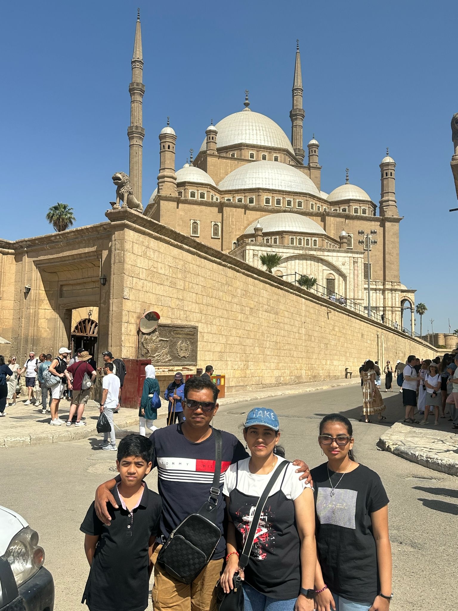 People walking near a large mosque structure.