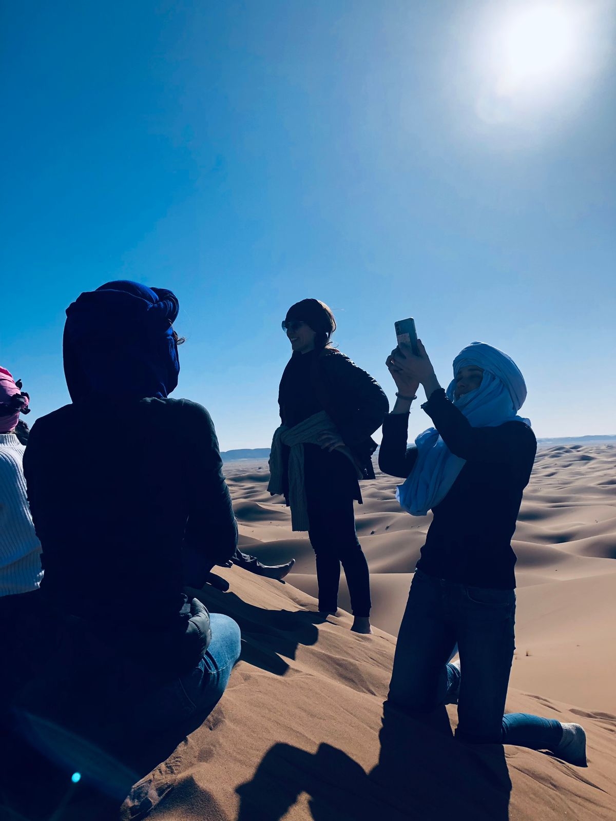 People exploring sand dunes in a desert.