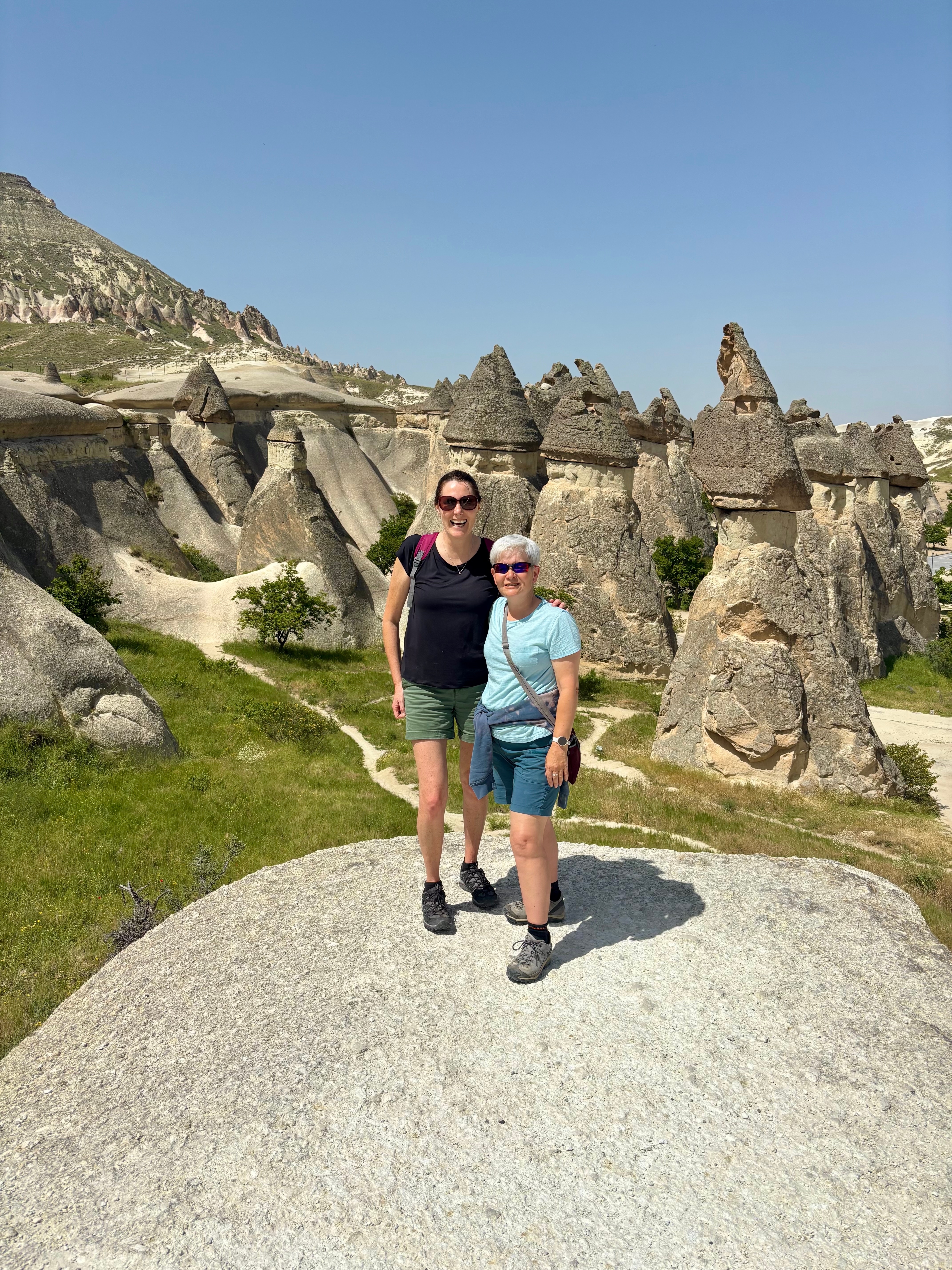 Two people in a rocky landscape with unique rock formations.