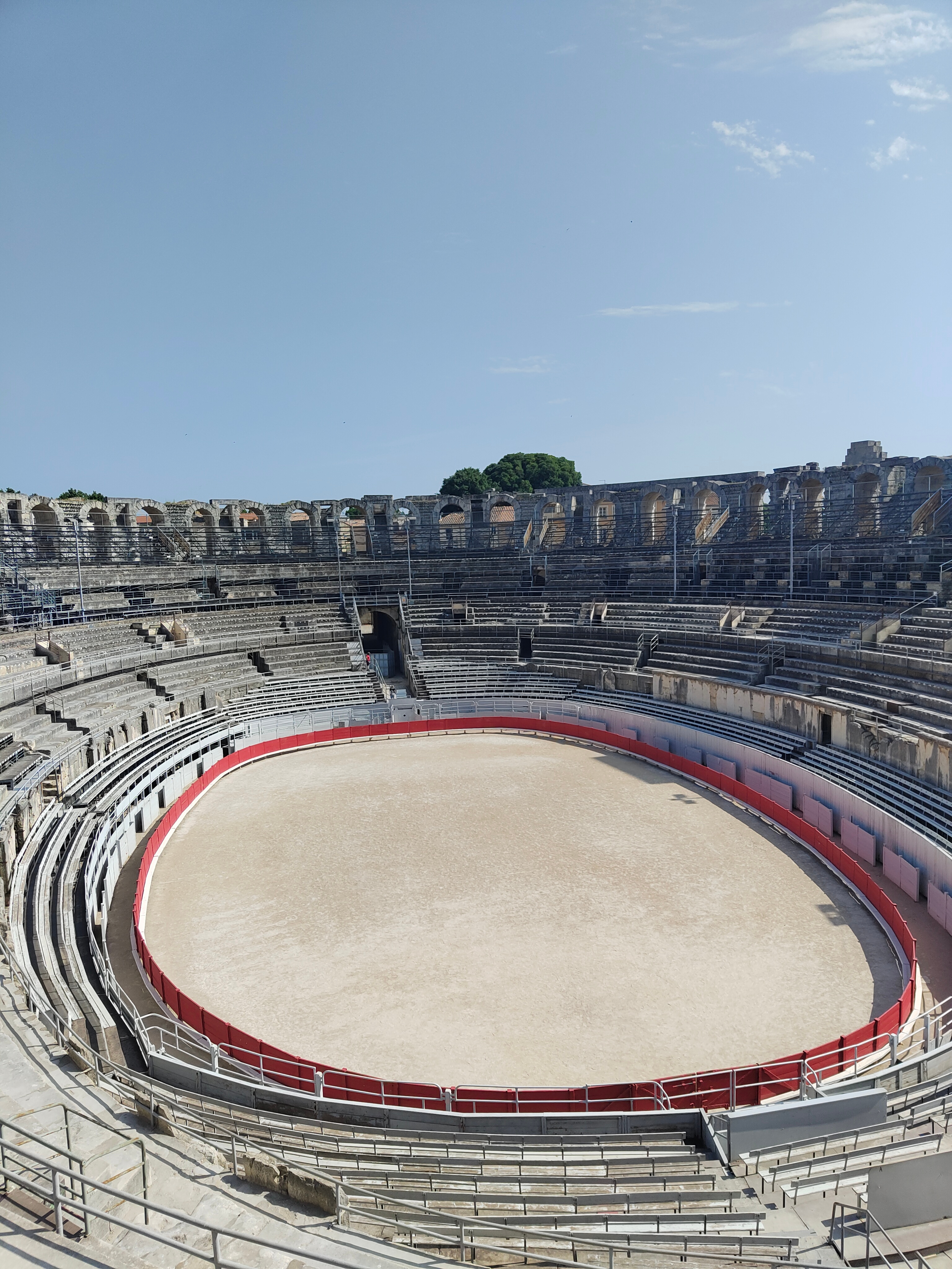 Amphitheater with tiered seating and a sandy arena.