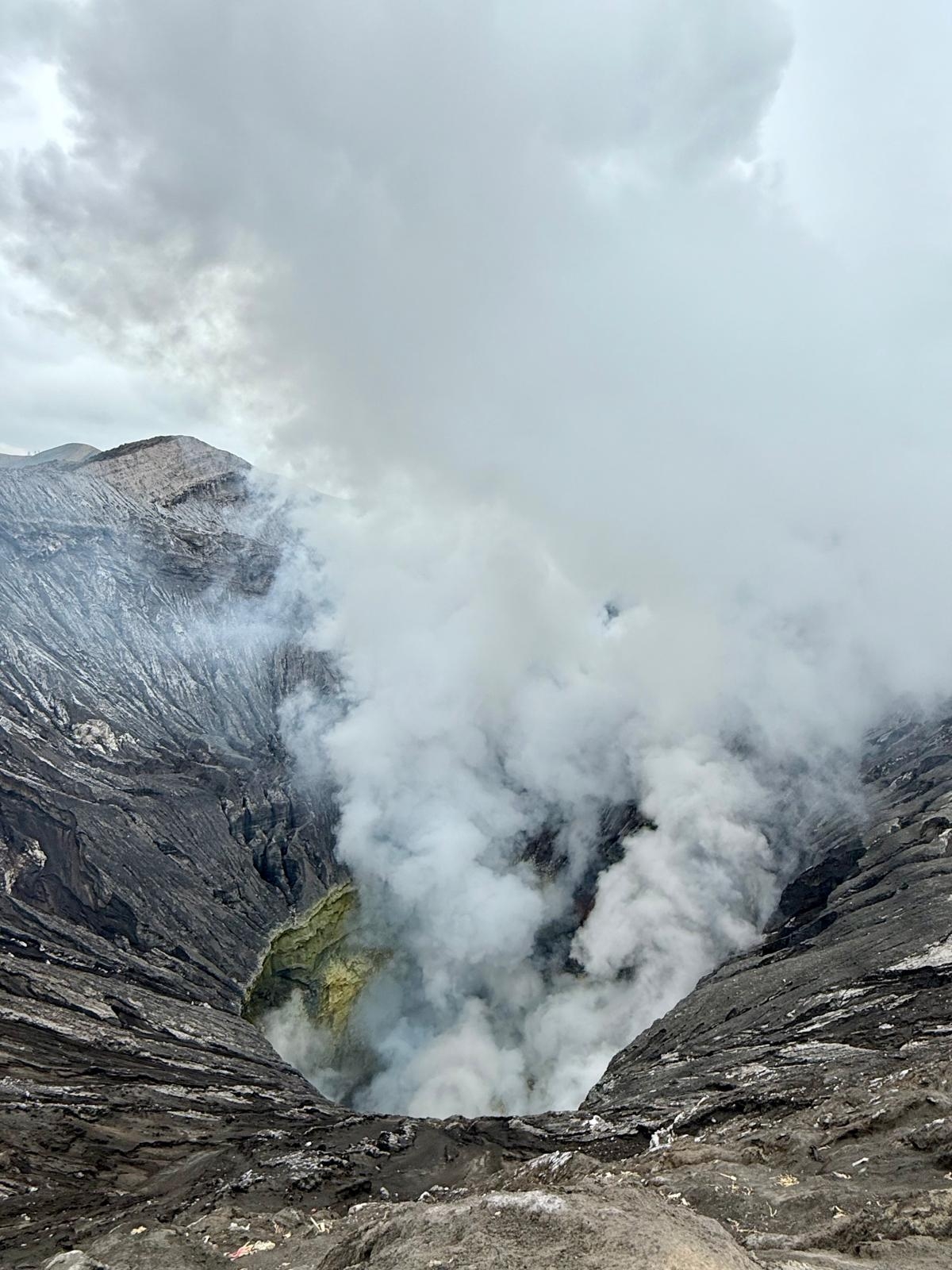 Volcanic crater emitting steam and gases.