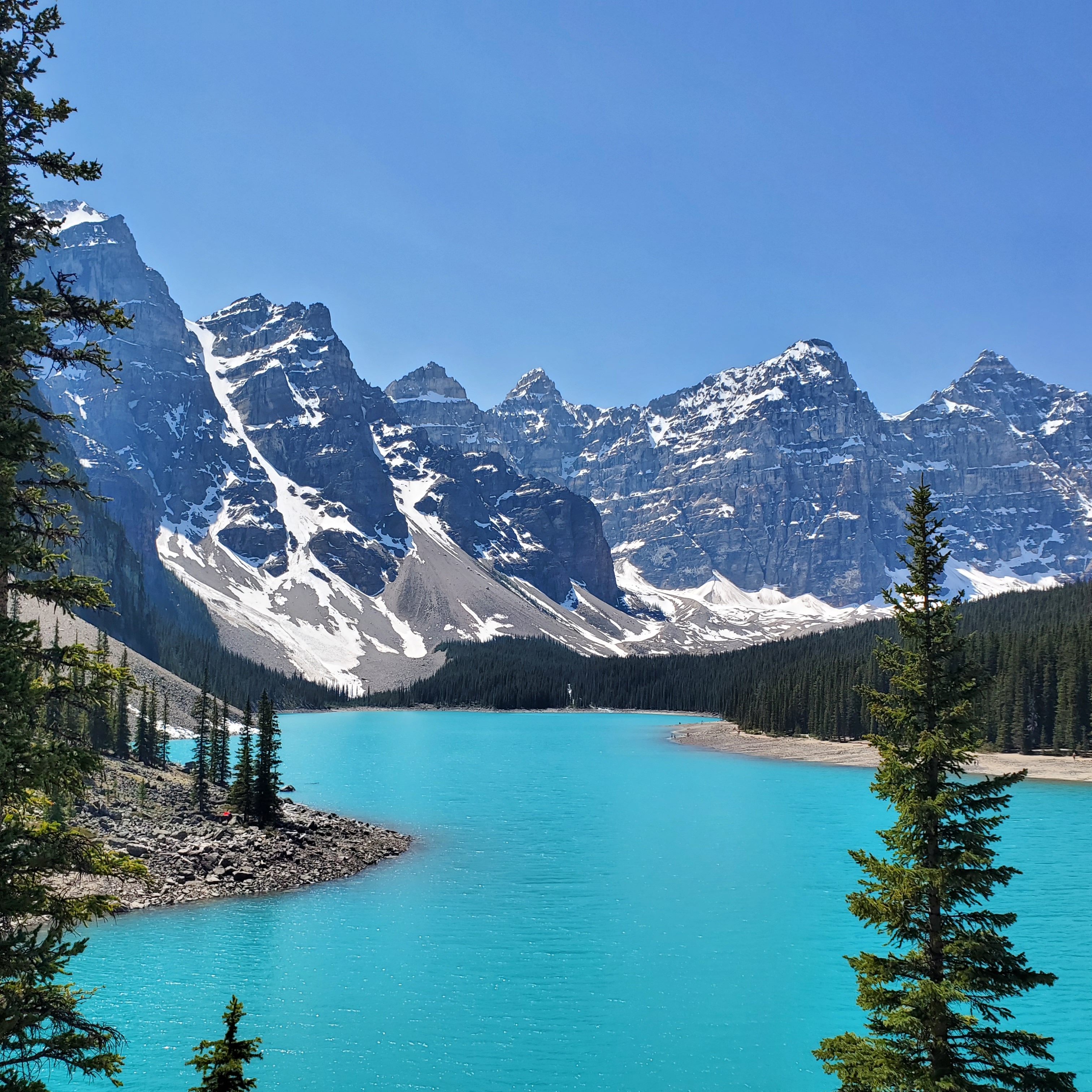 Stunning turquoise alpine lake surrounded by snow-capped mountains.